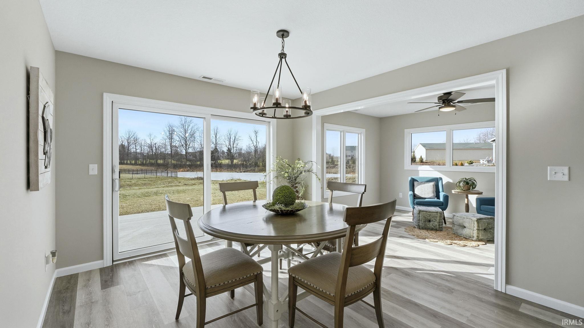Dining area featuring light wood-style floors, a ceiling fan, healthy amount of natural light, and a chandelier