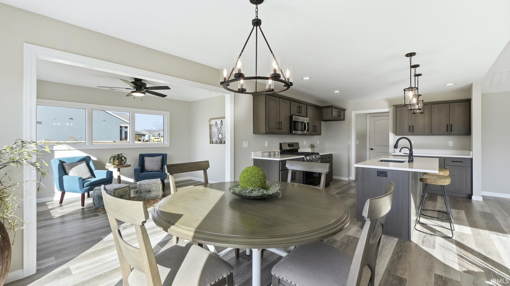 Dining area with a ceiling fan, a chandelier, light wood finished floors, and recessed lighting