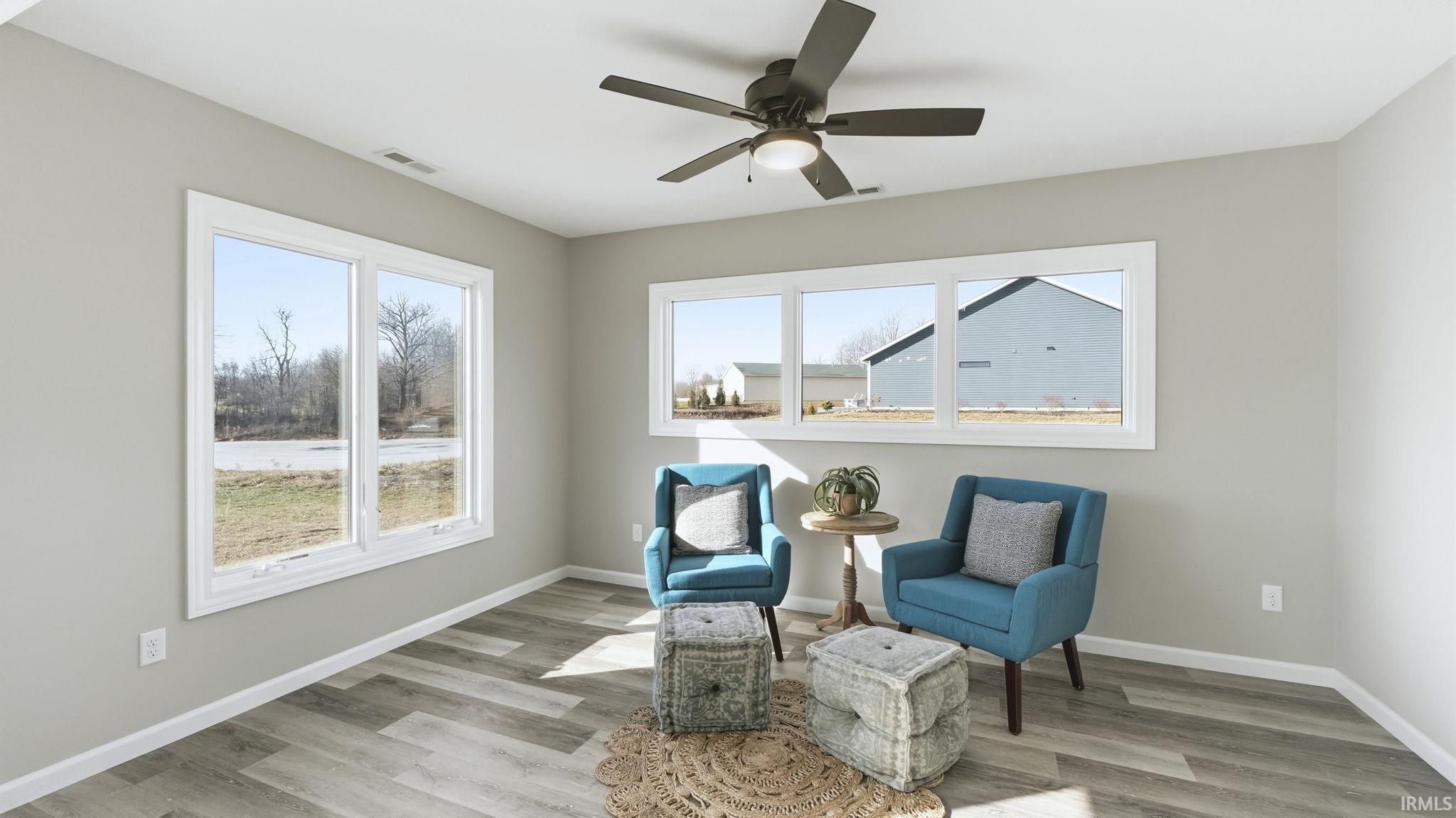 Sitting room featuring plenty of natural light, light wood-style flooring, and ceiling fan