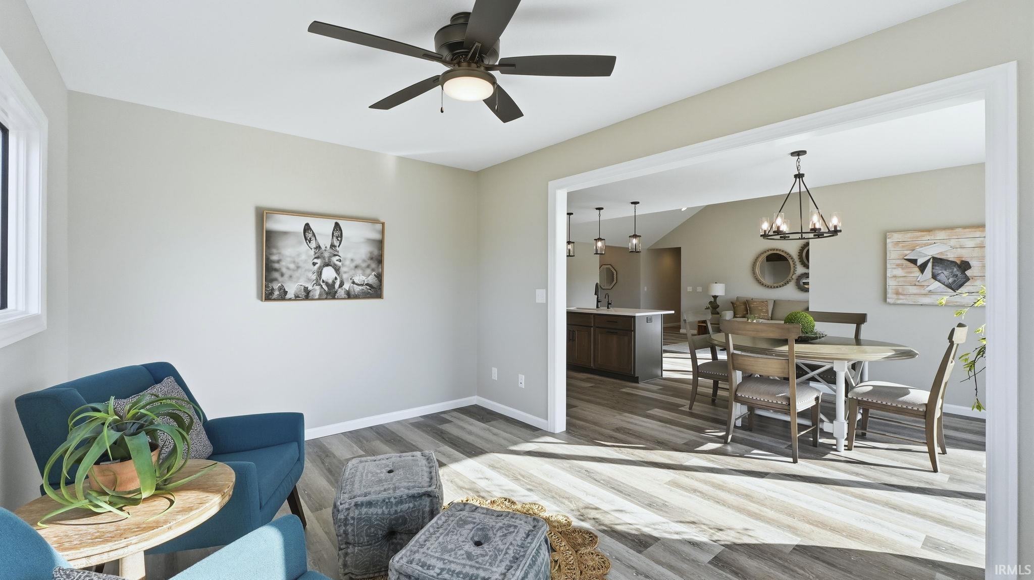 Living room with light wood-type flooring, a chandelier, and ceiling fan
