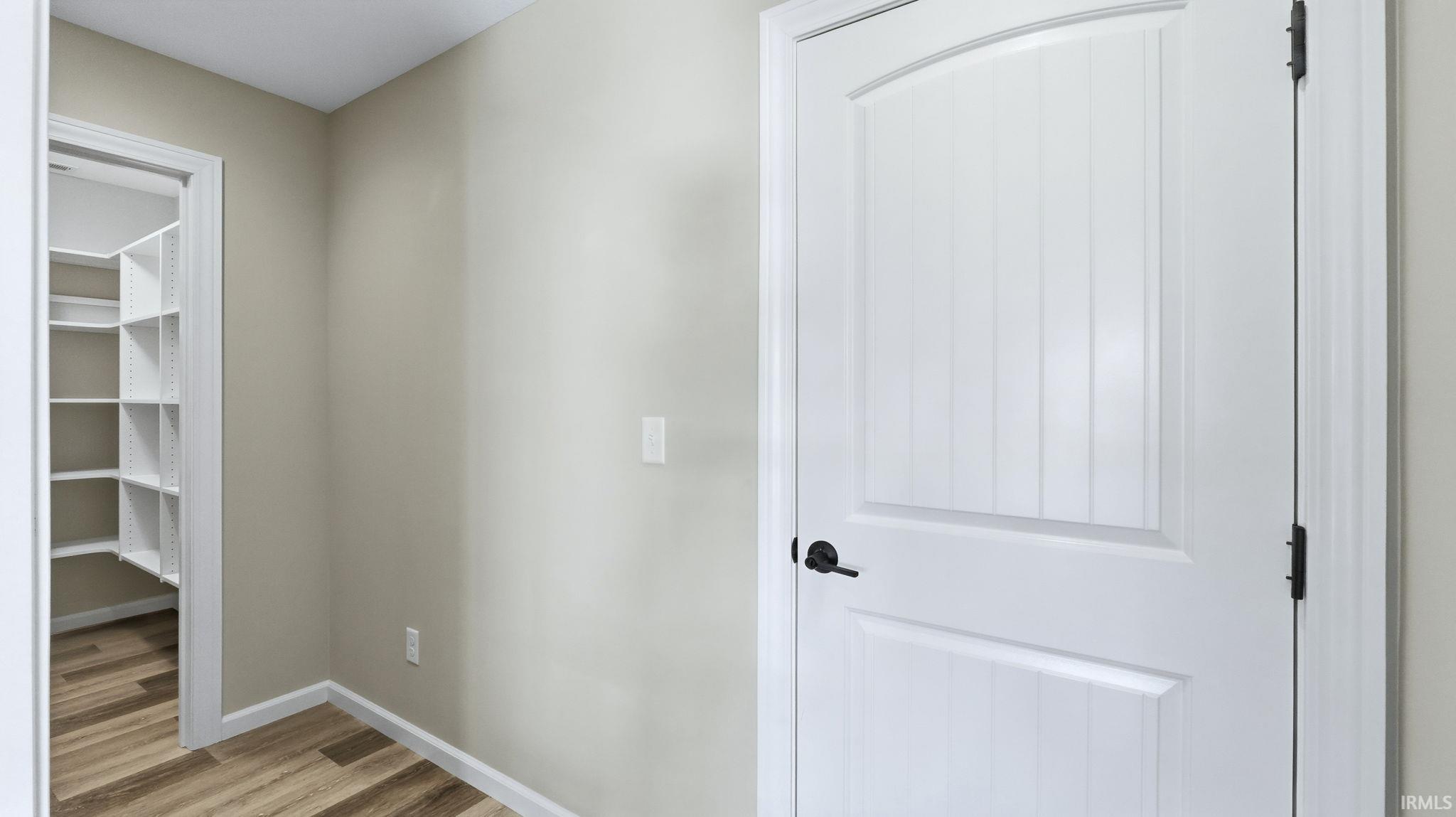 Hallway featuring wood finished floors and baseboards