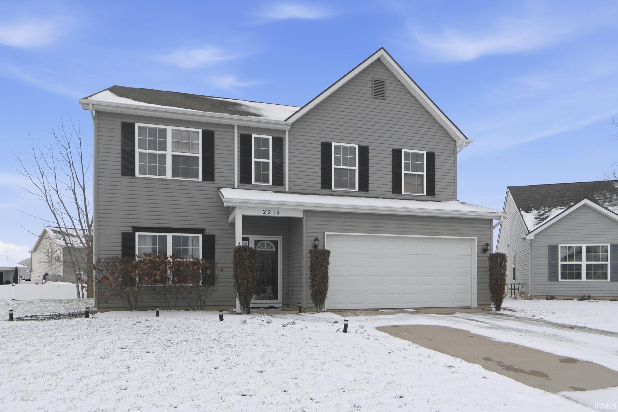 Traditional-style home featuring an attached garage and driveway