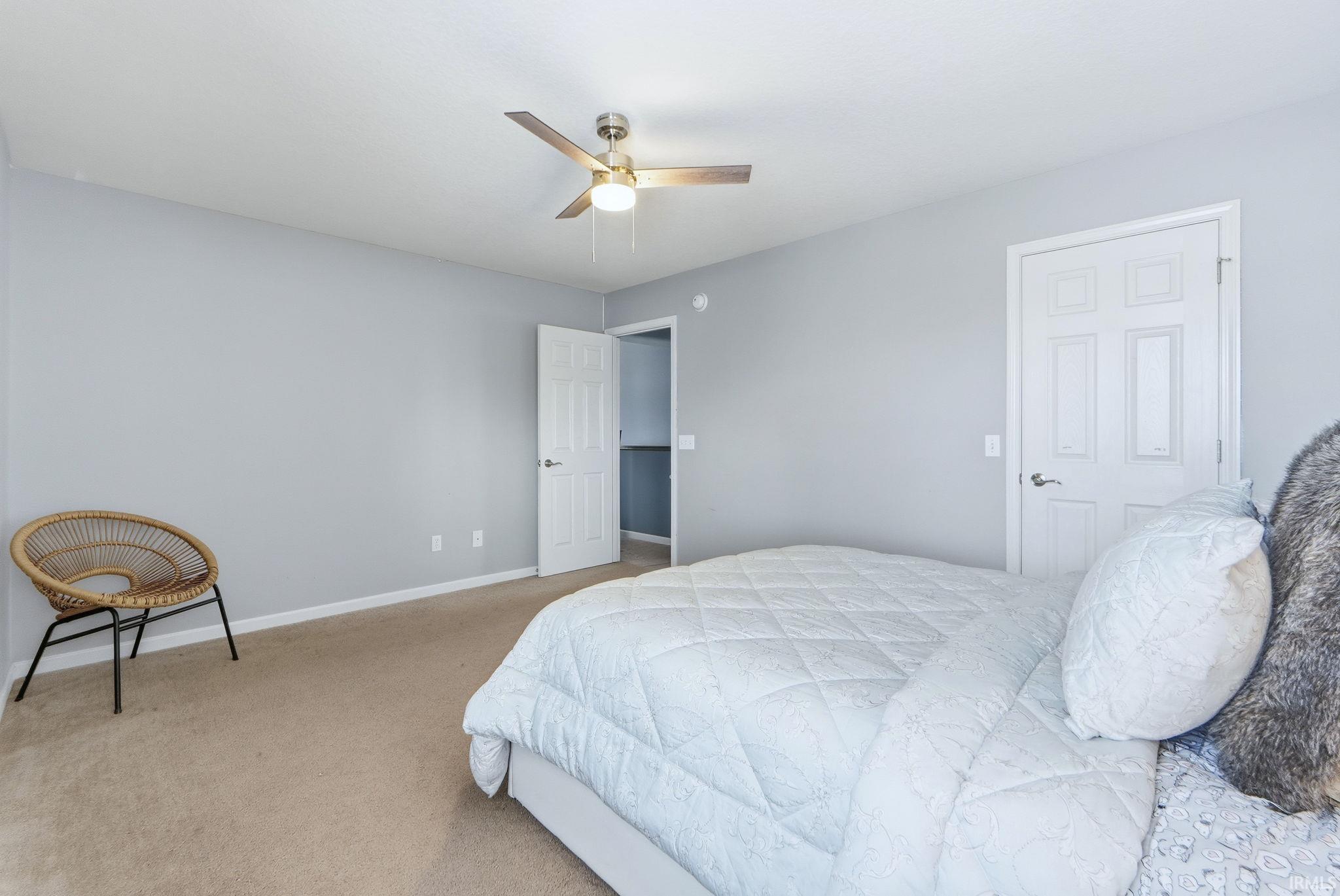Carpeted bedroom featuring ceiling fan and baseboards