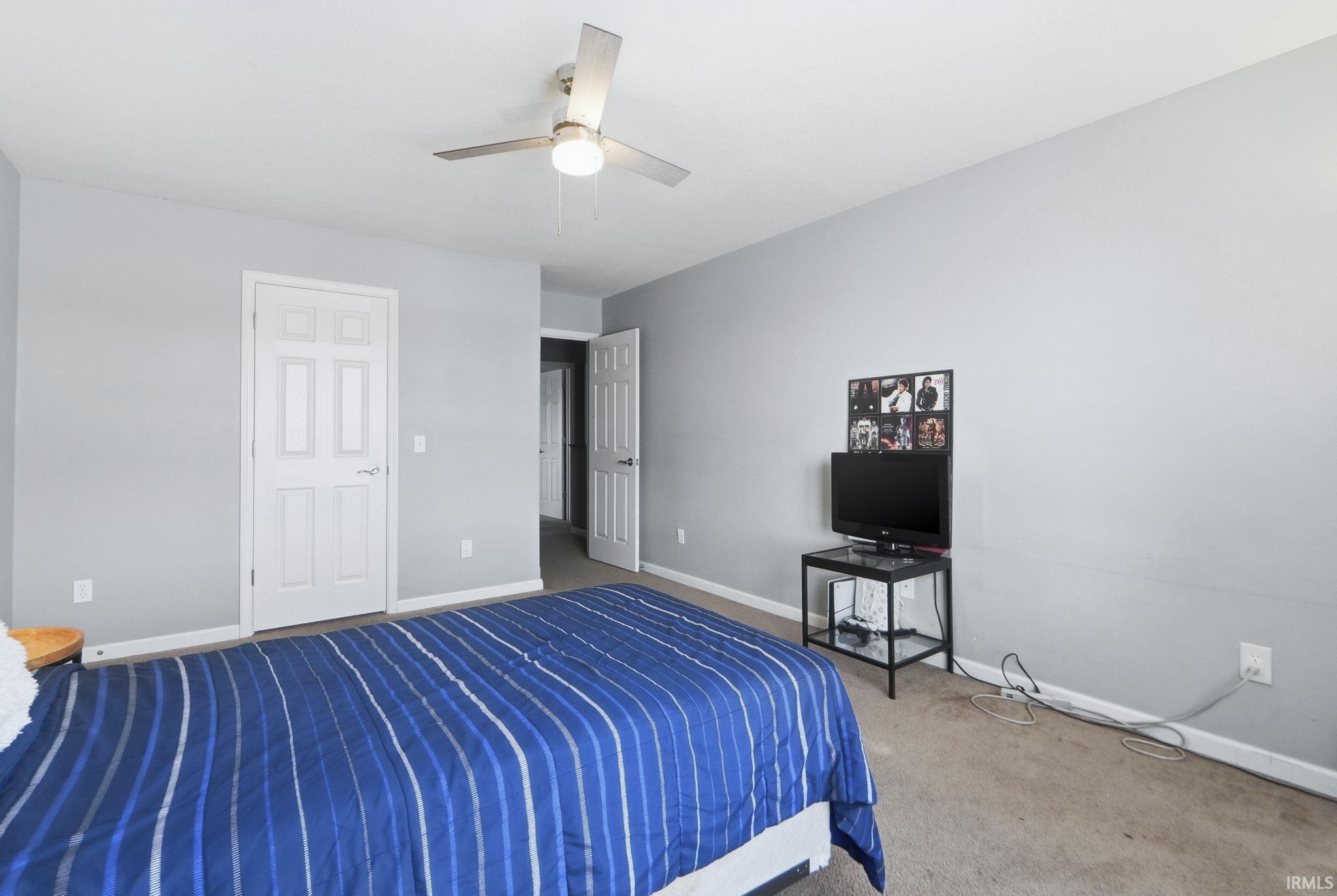 Carpeted bedroom featuring baseboards and a ceiling fan