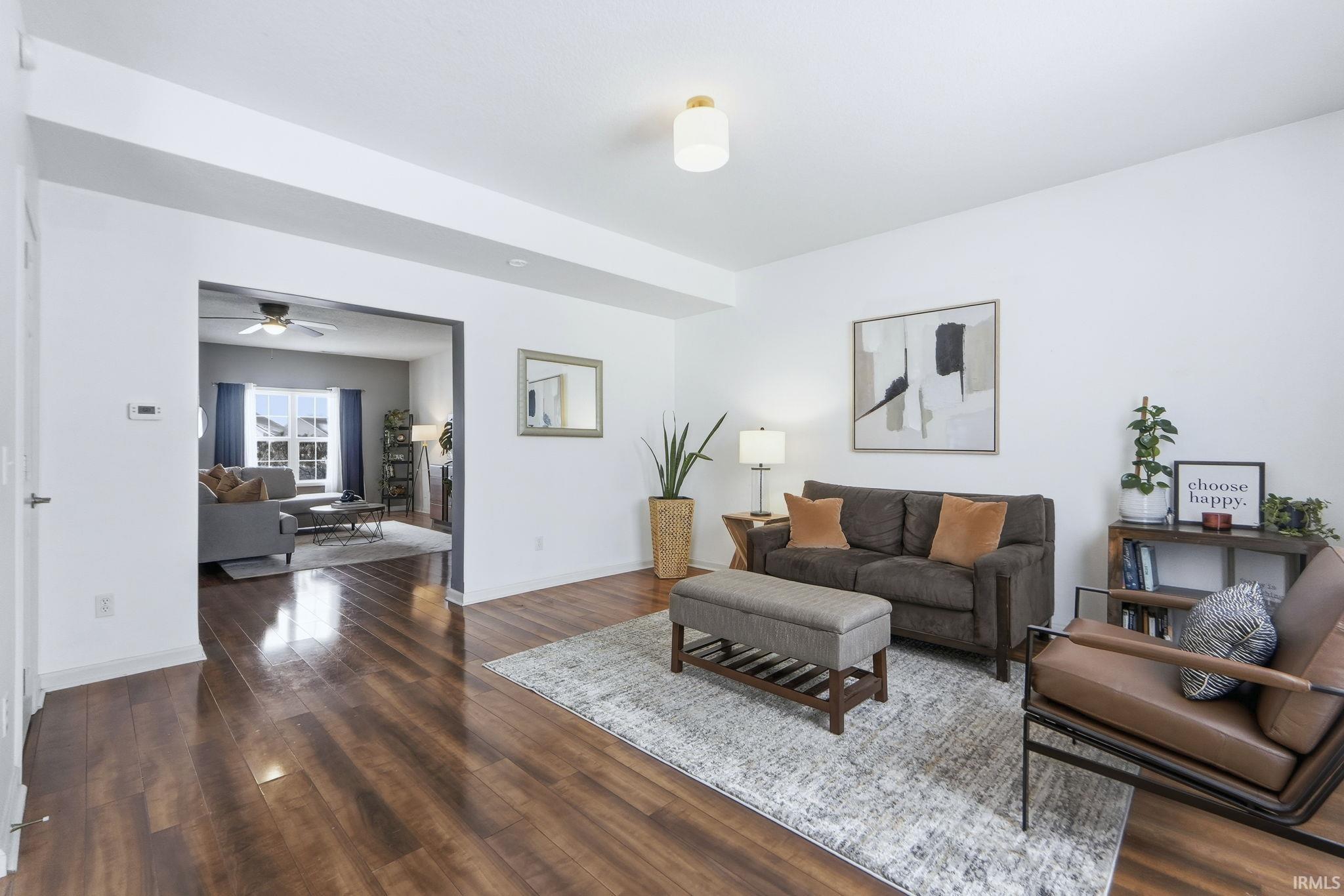 Living room featuring dark wood-style flooring and a ceiling fan