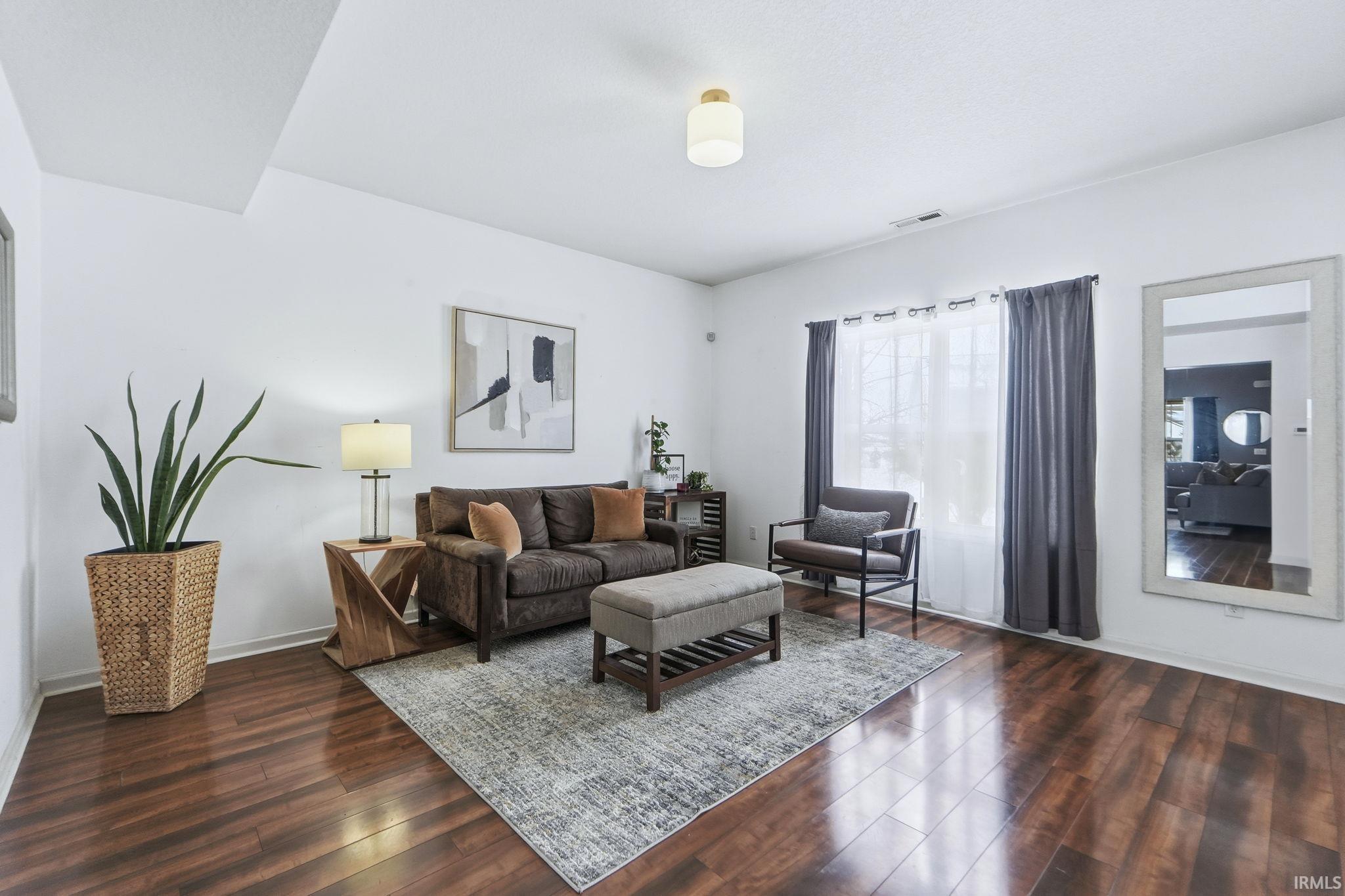 Living room featuring dark wood-style flooring and baseboards
