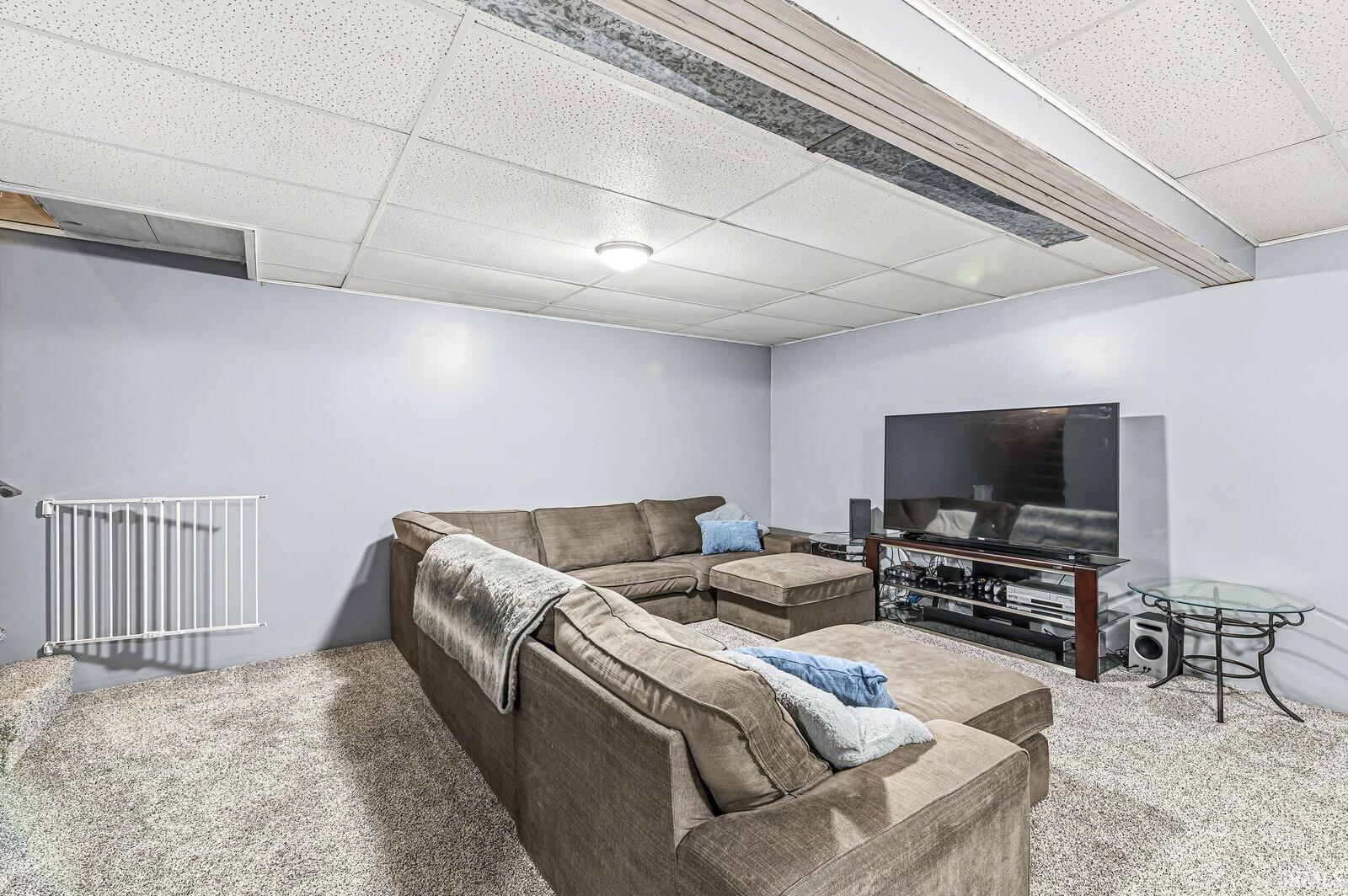 Living area with carpet flooring and a paneled ceiling
