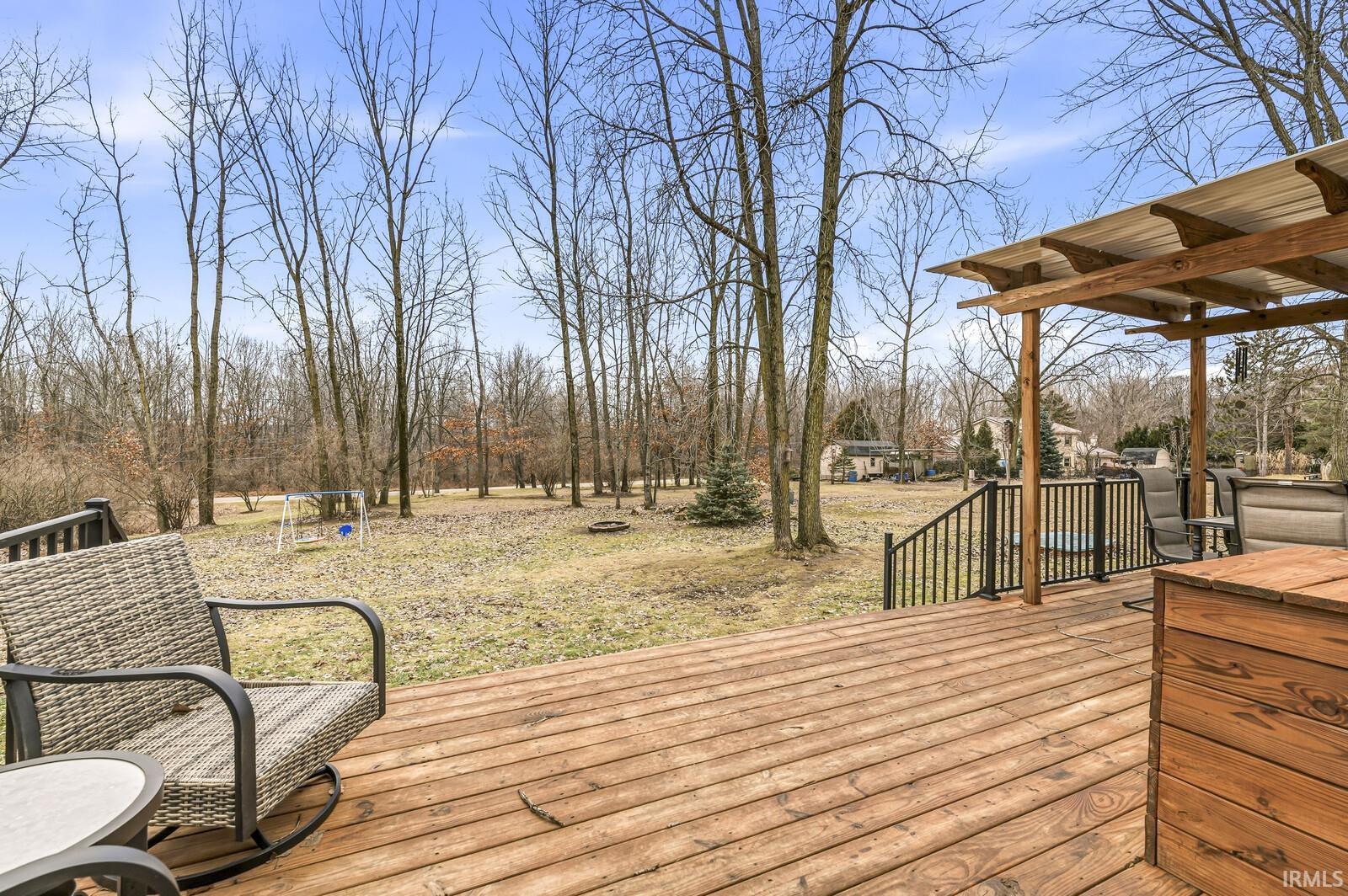 Wooden terrace featuring view of scattered trees