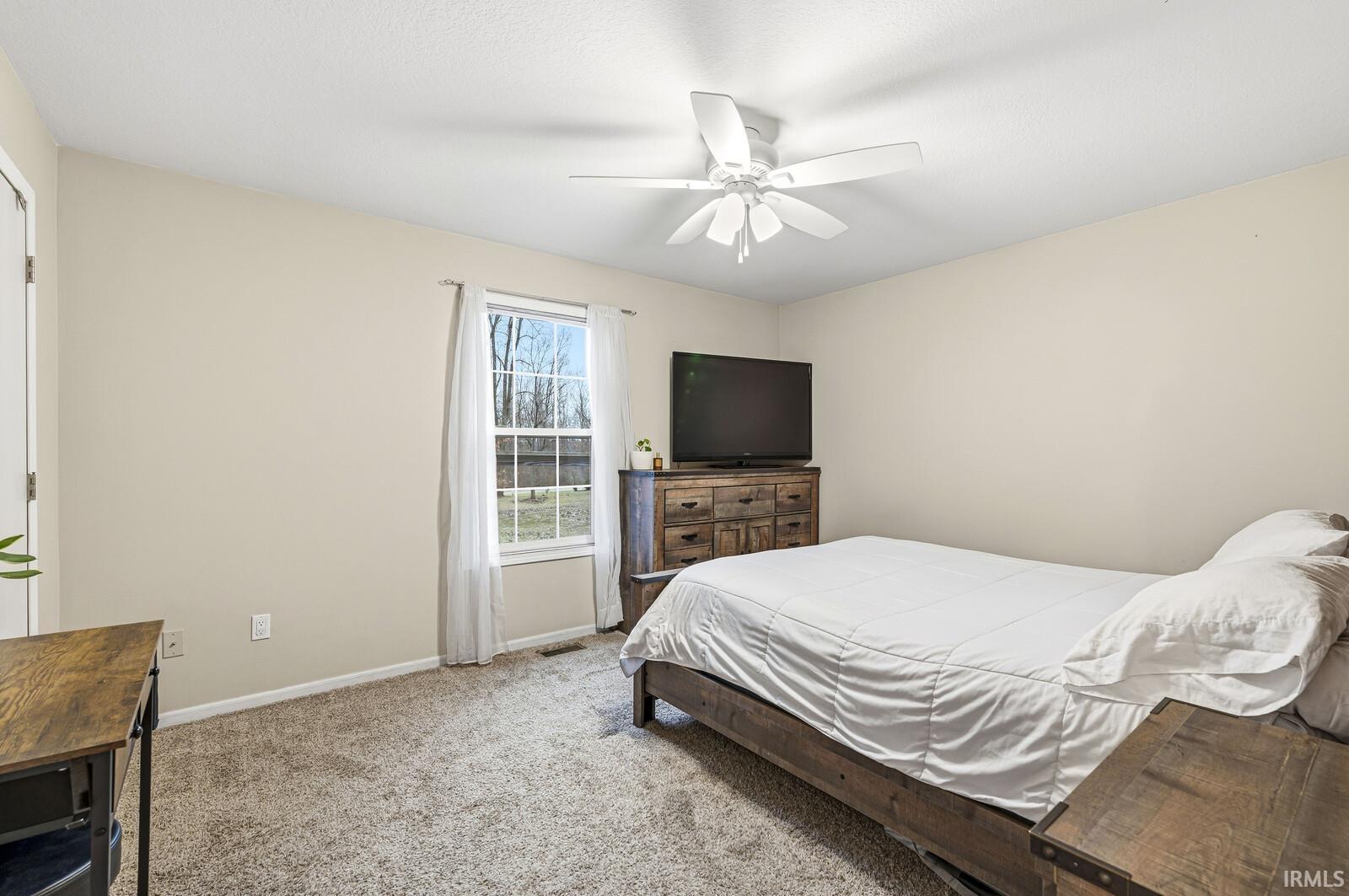 Bedroom with carpet and a ceiling fan