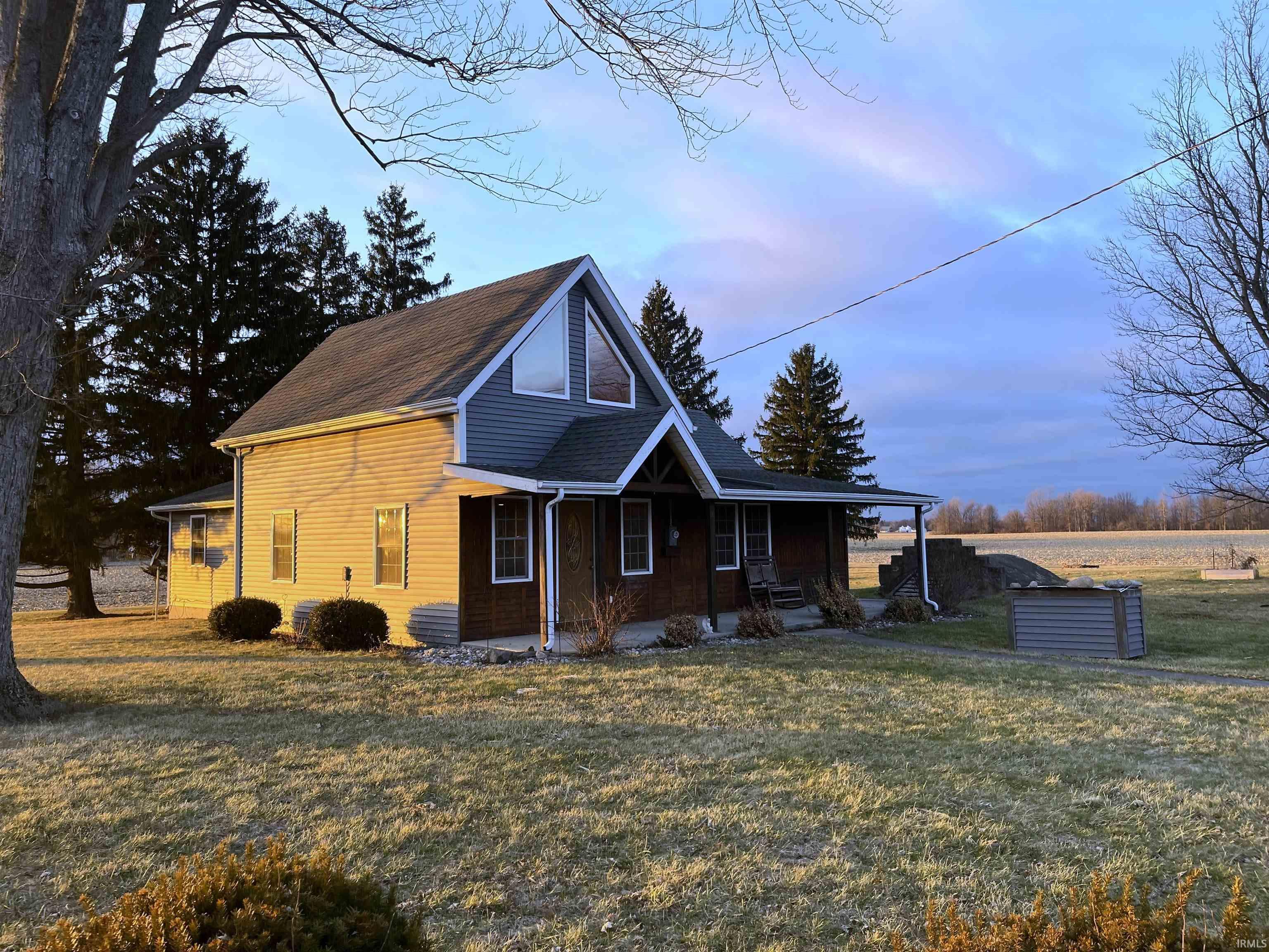 View of front of home featuring covered porch and a front lawn