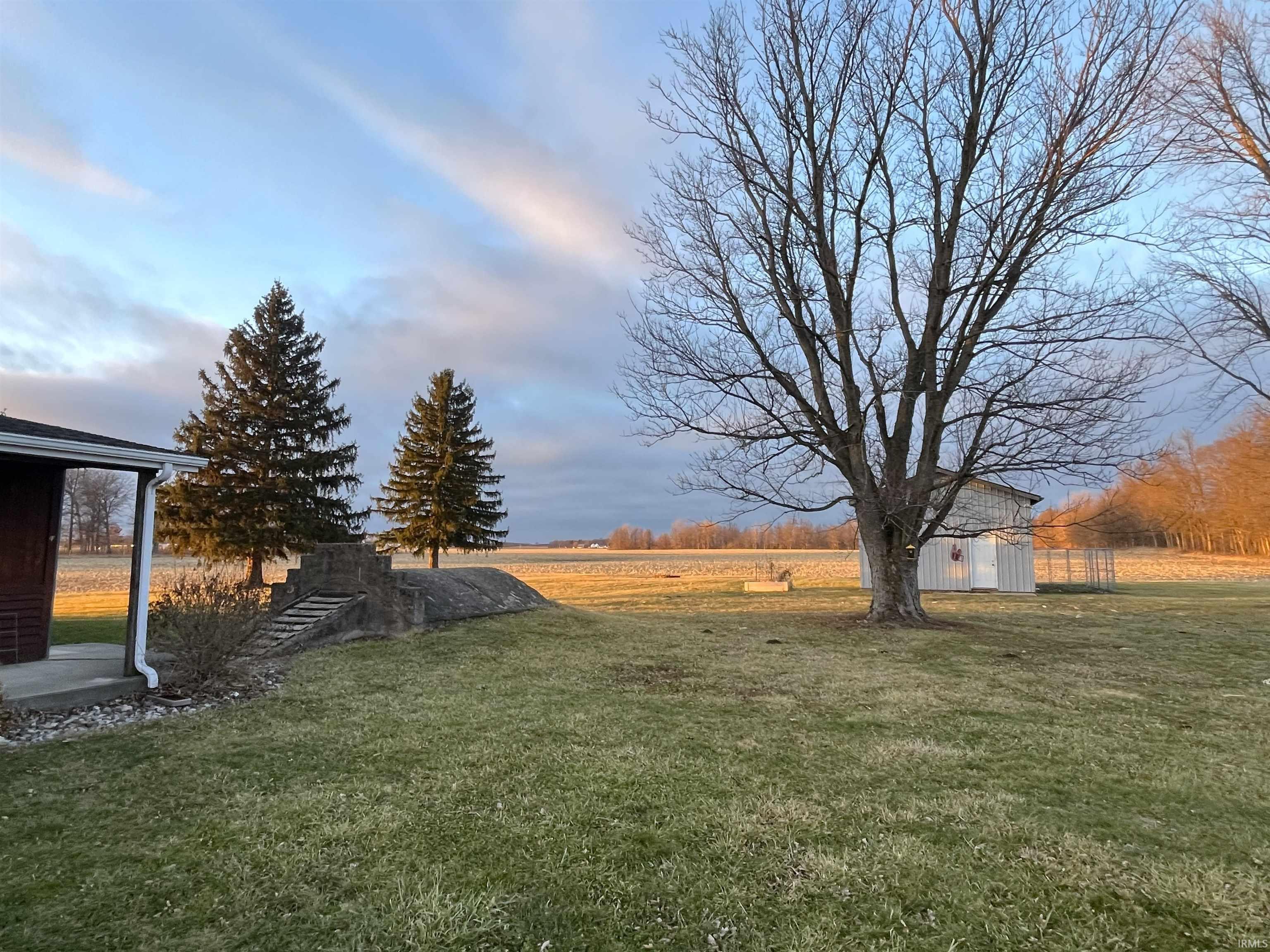 View of grassy yard featuring a storage shed and a view of rural / pastoral area