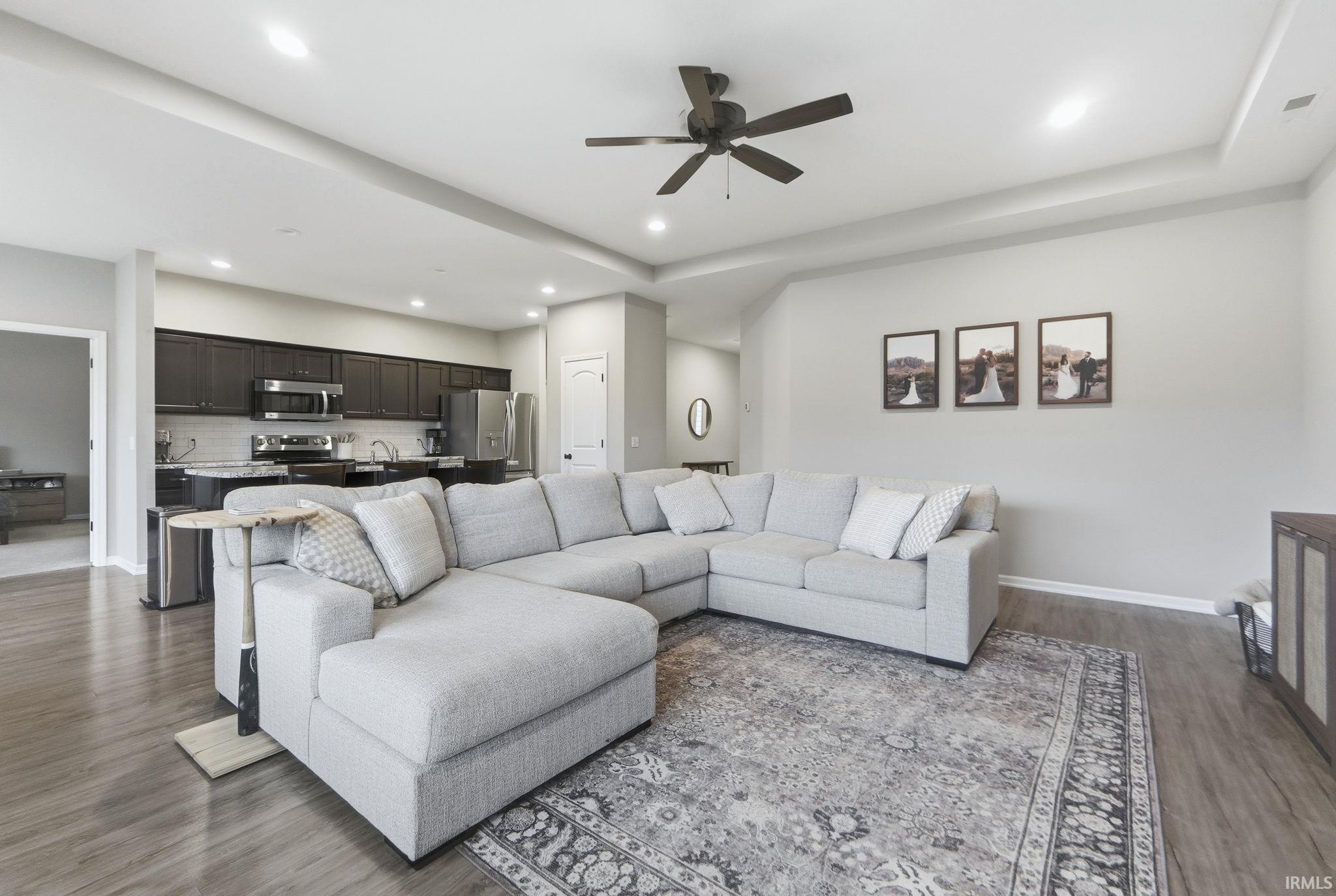 Living room with ceiling fan, wood finished floors, and recessed lighting