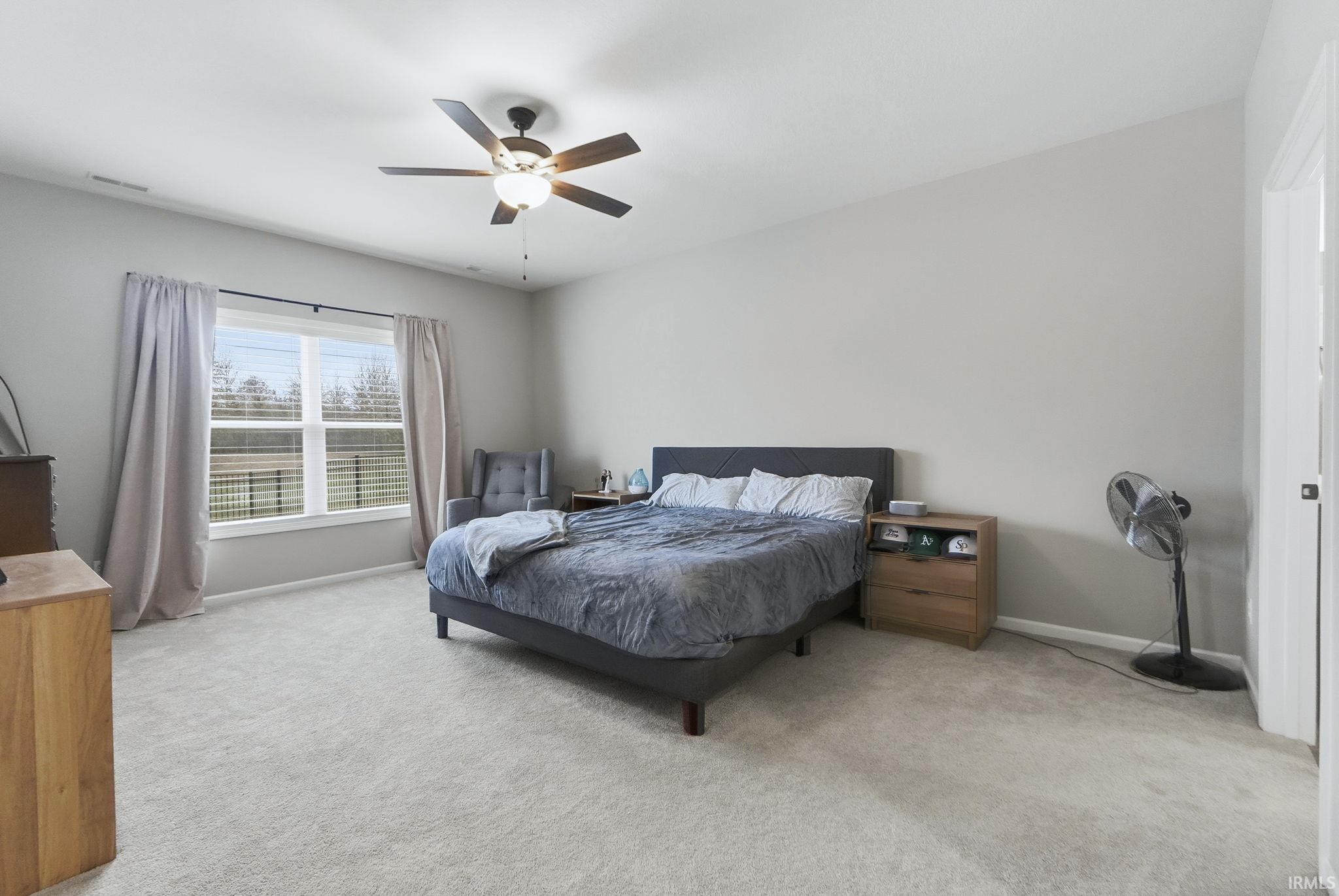 Bedroom featuring light colored carpet and a ceiling fan