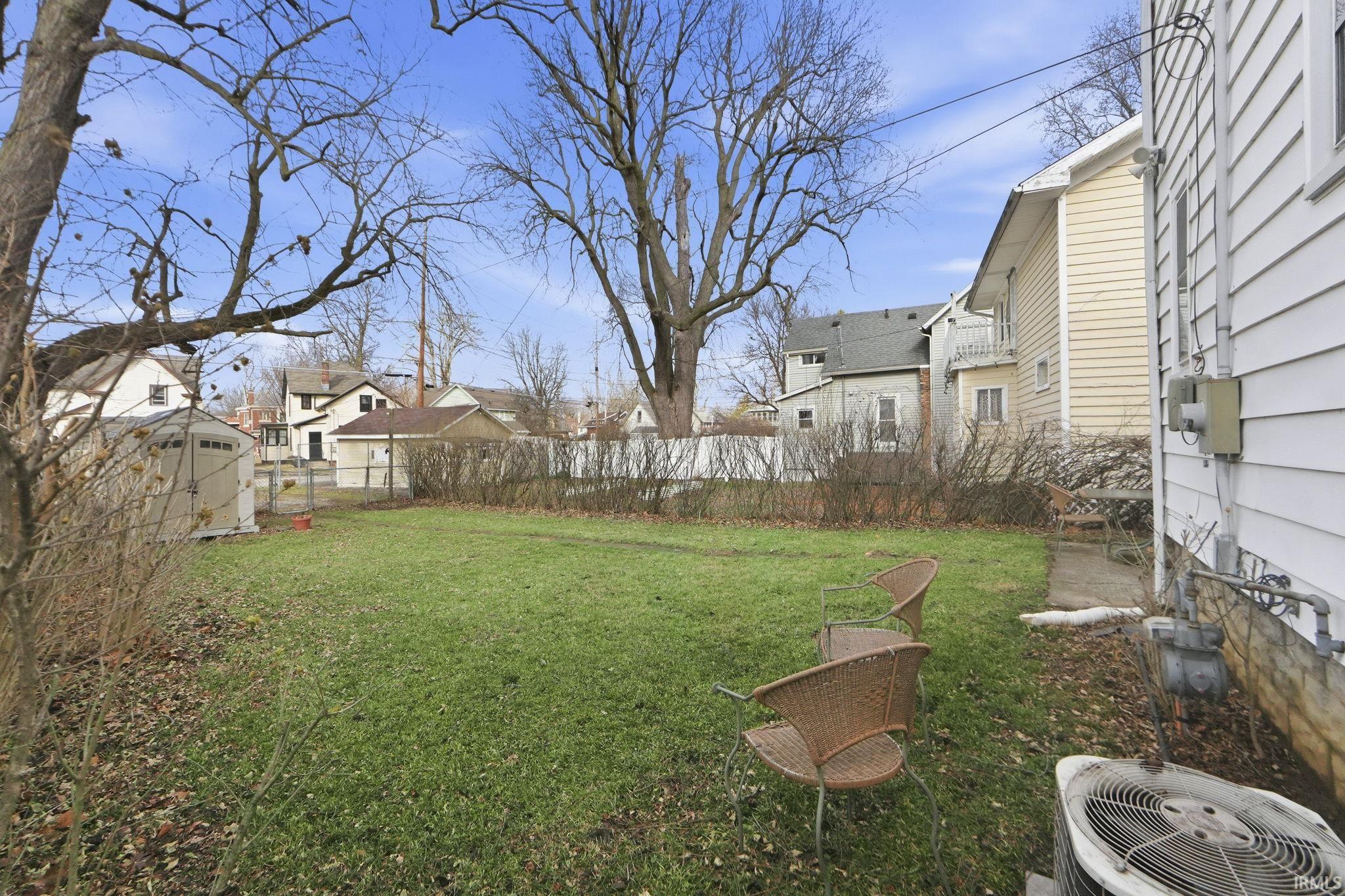 Fenced backyard featuring a residential view and an outbuilding