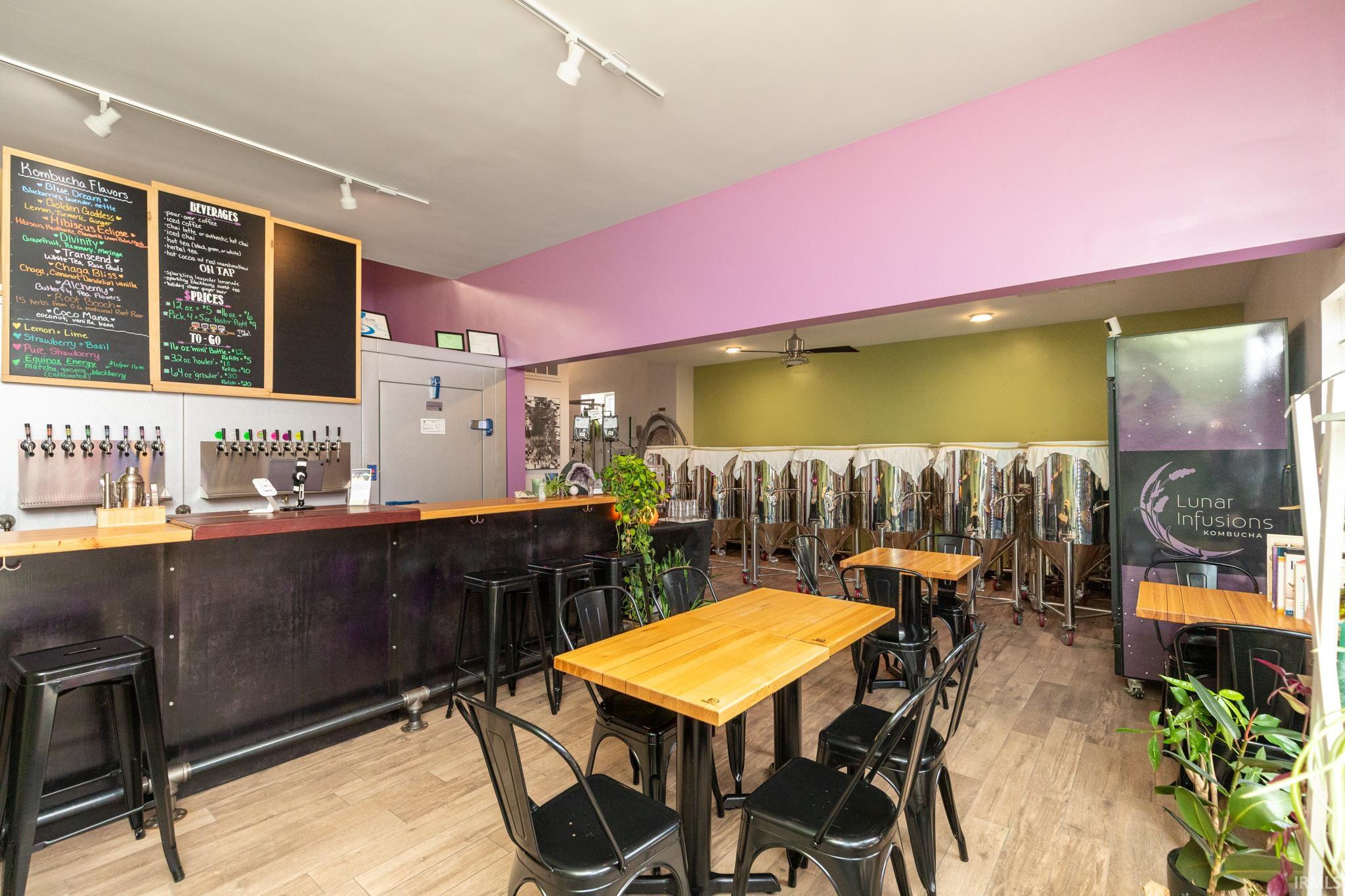 Dining area with rail lighting, light wood-style floors, and a ceiling fan