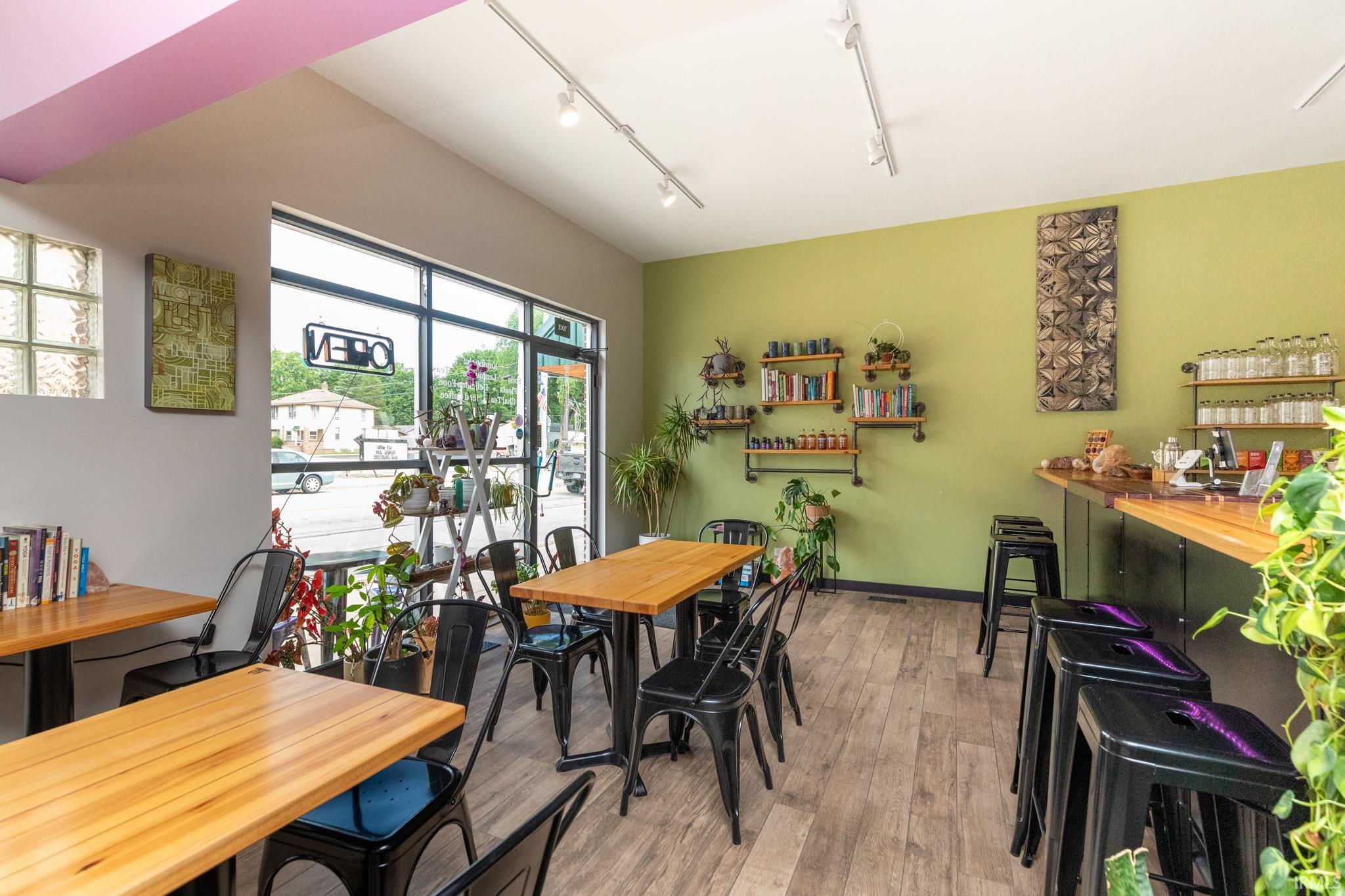 Dining area with light wood-style floors and rail lighting