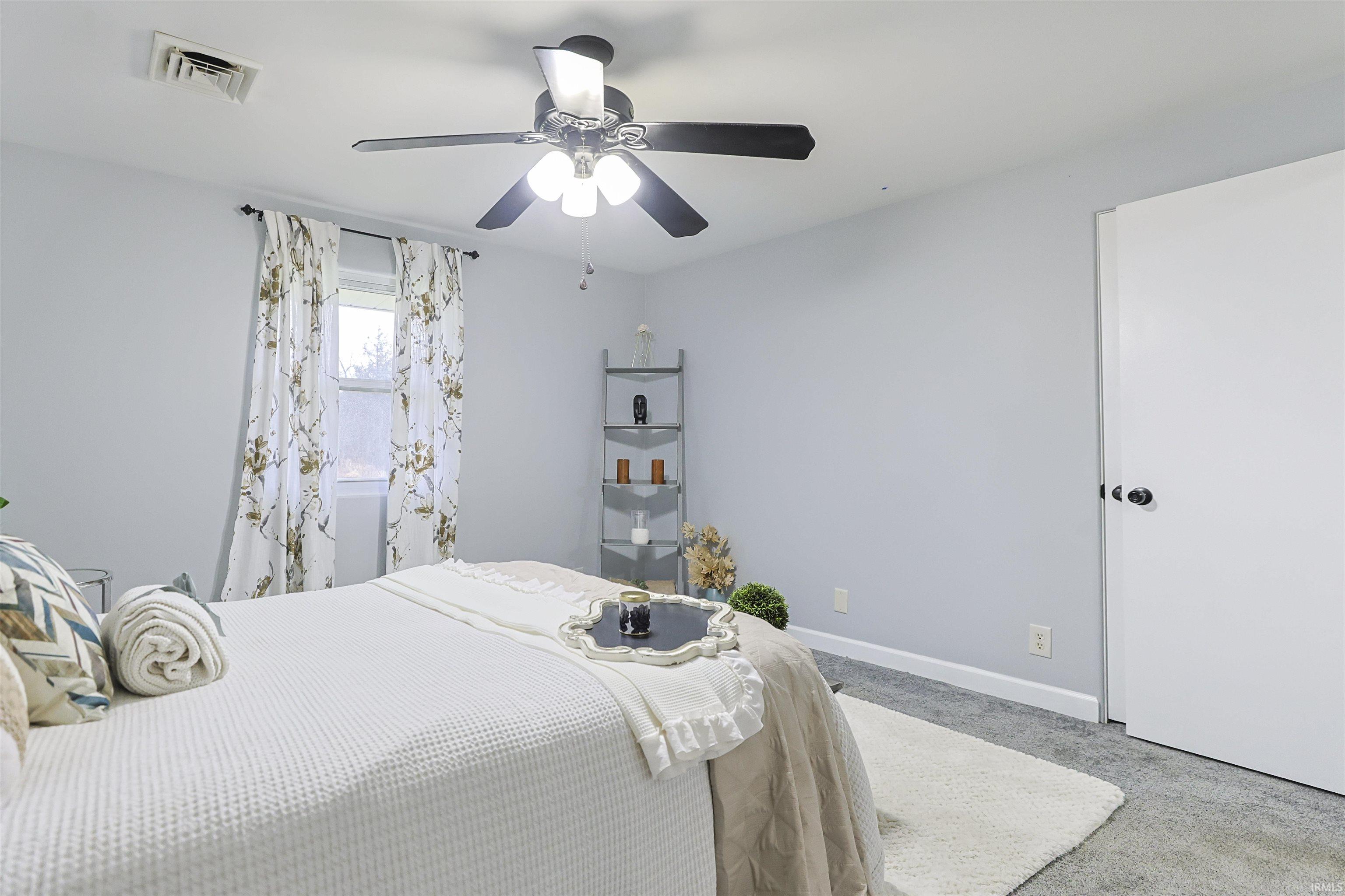 Carpeted bedroom featuring baseboards and ceiling fan
