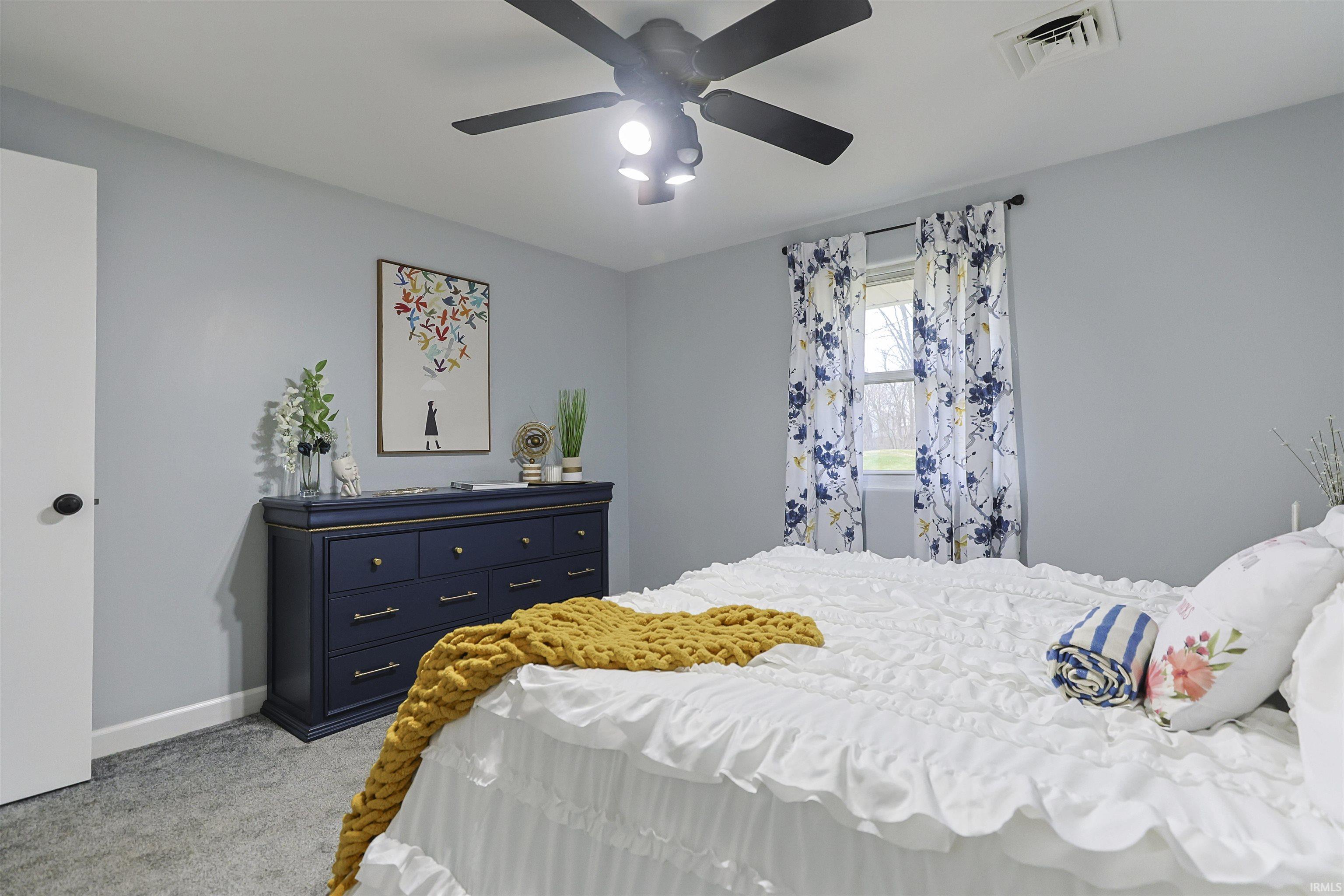 Bedroom with light carpet and ceiling fan