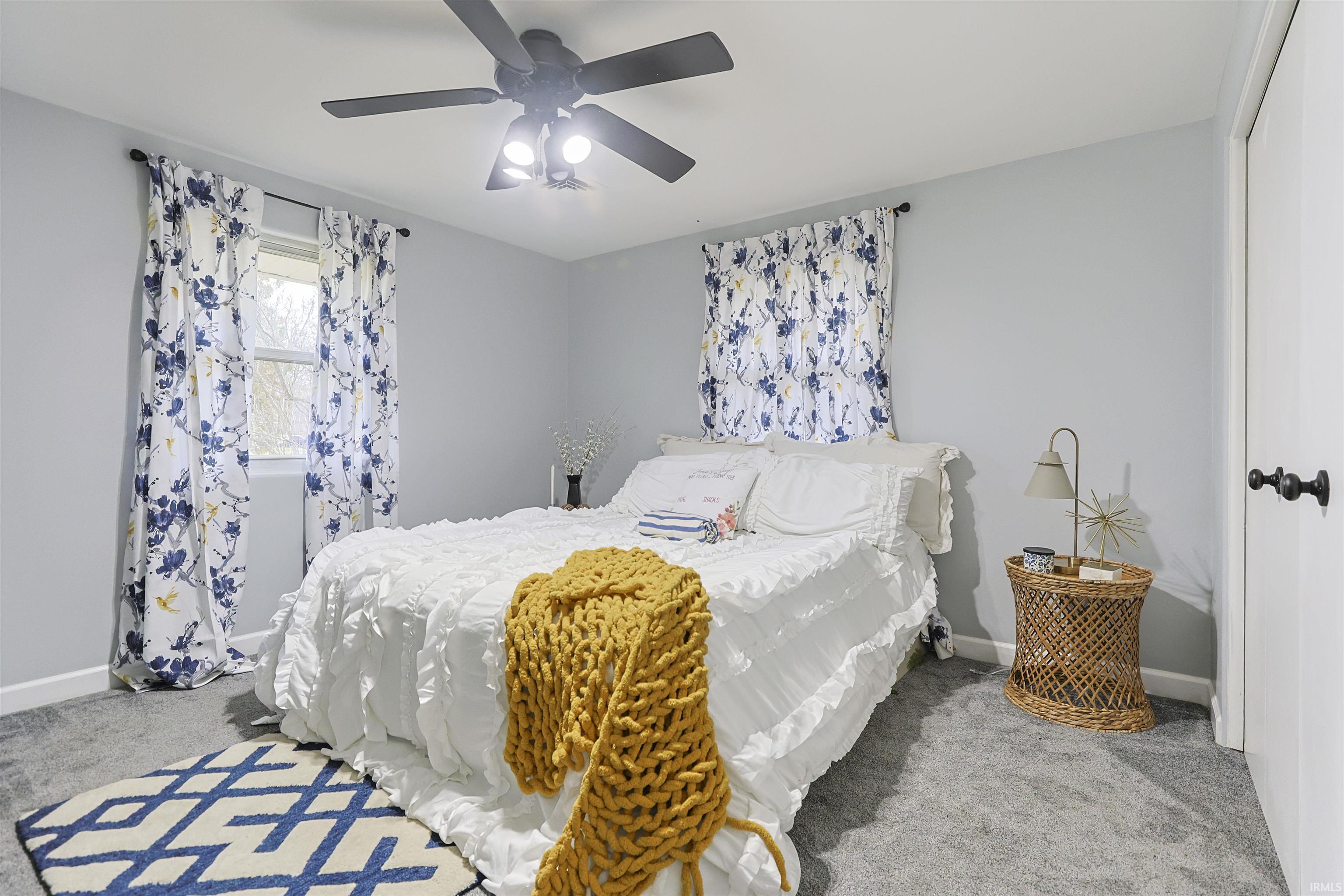 Bedroom featuring light colored carpet, a ceiling fan, and a closet