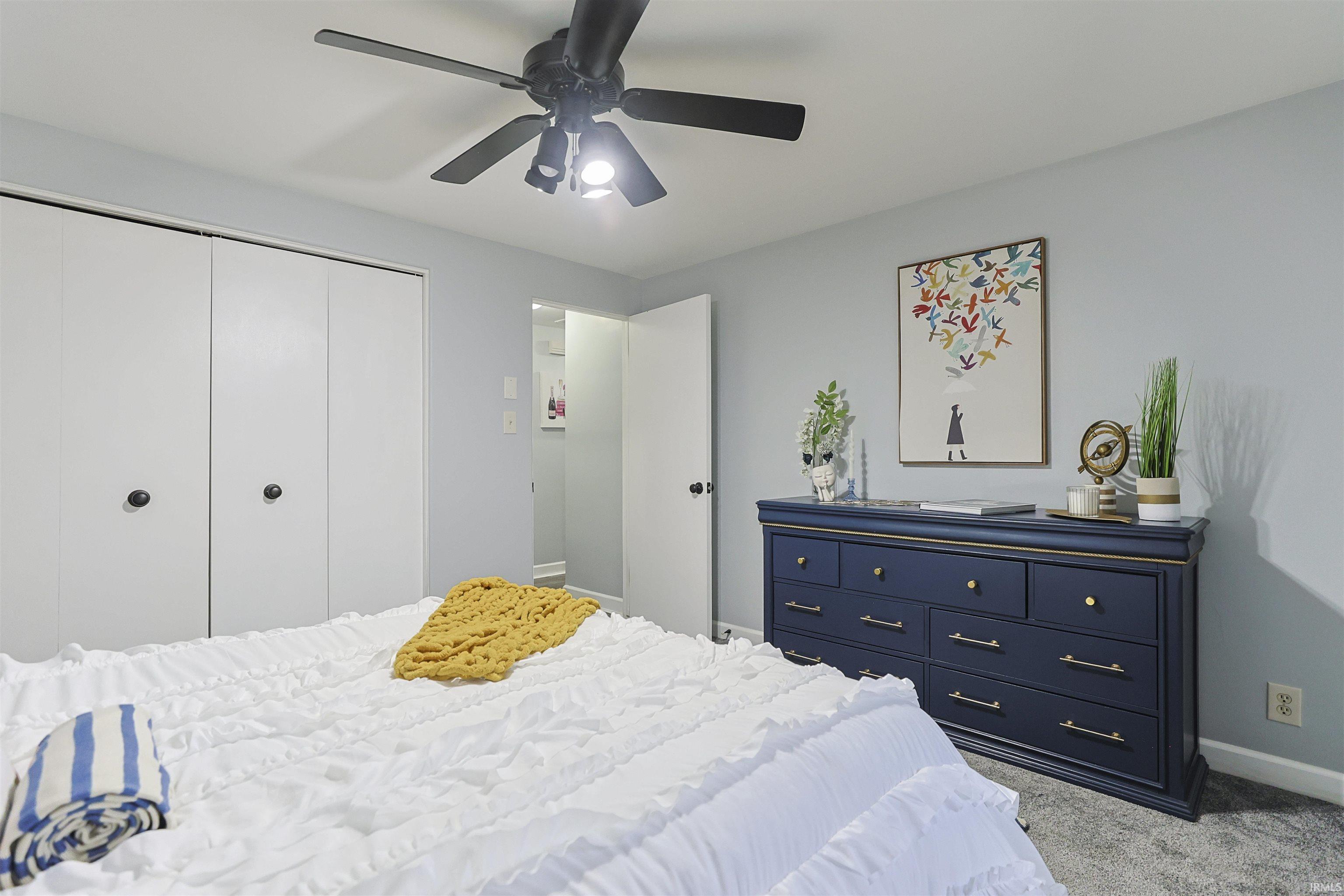 Bedroom with a closet, carpet, and ceiling fan