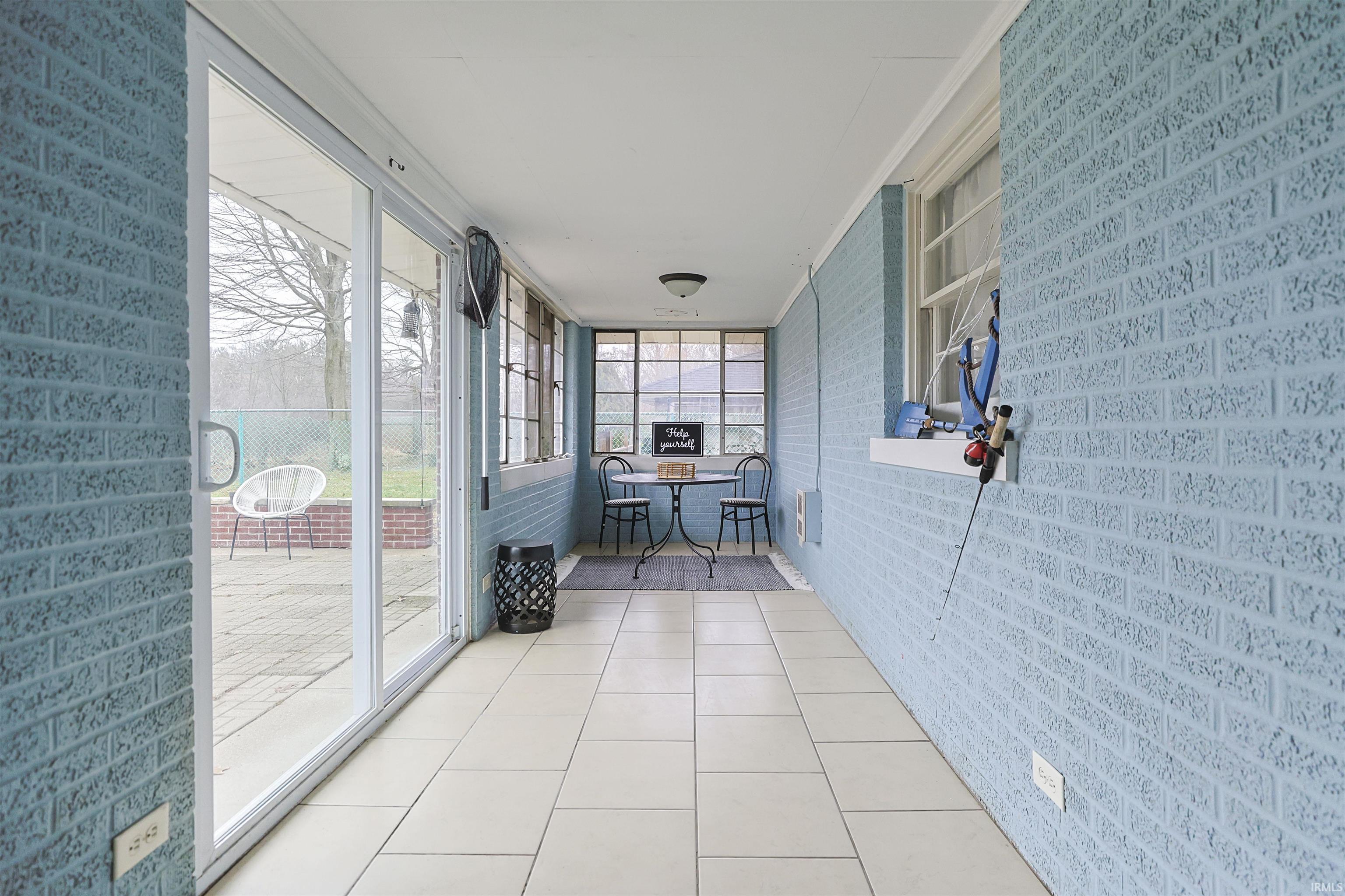 Sunroom / solarium featuring brick wall and tile patterned floors