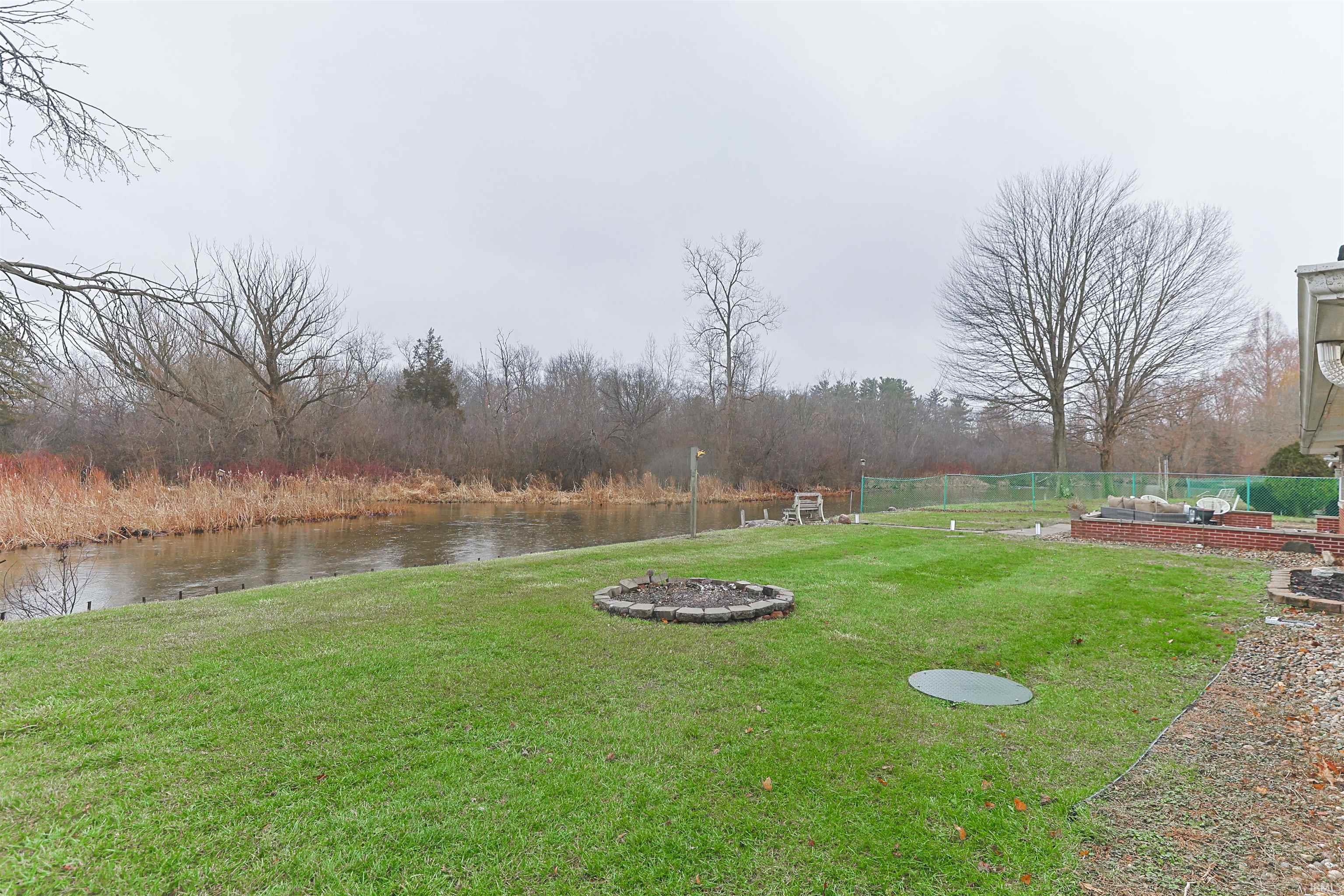 View of grassy yard featuring a vegetable garden and a water view