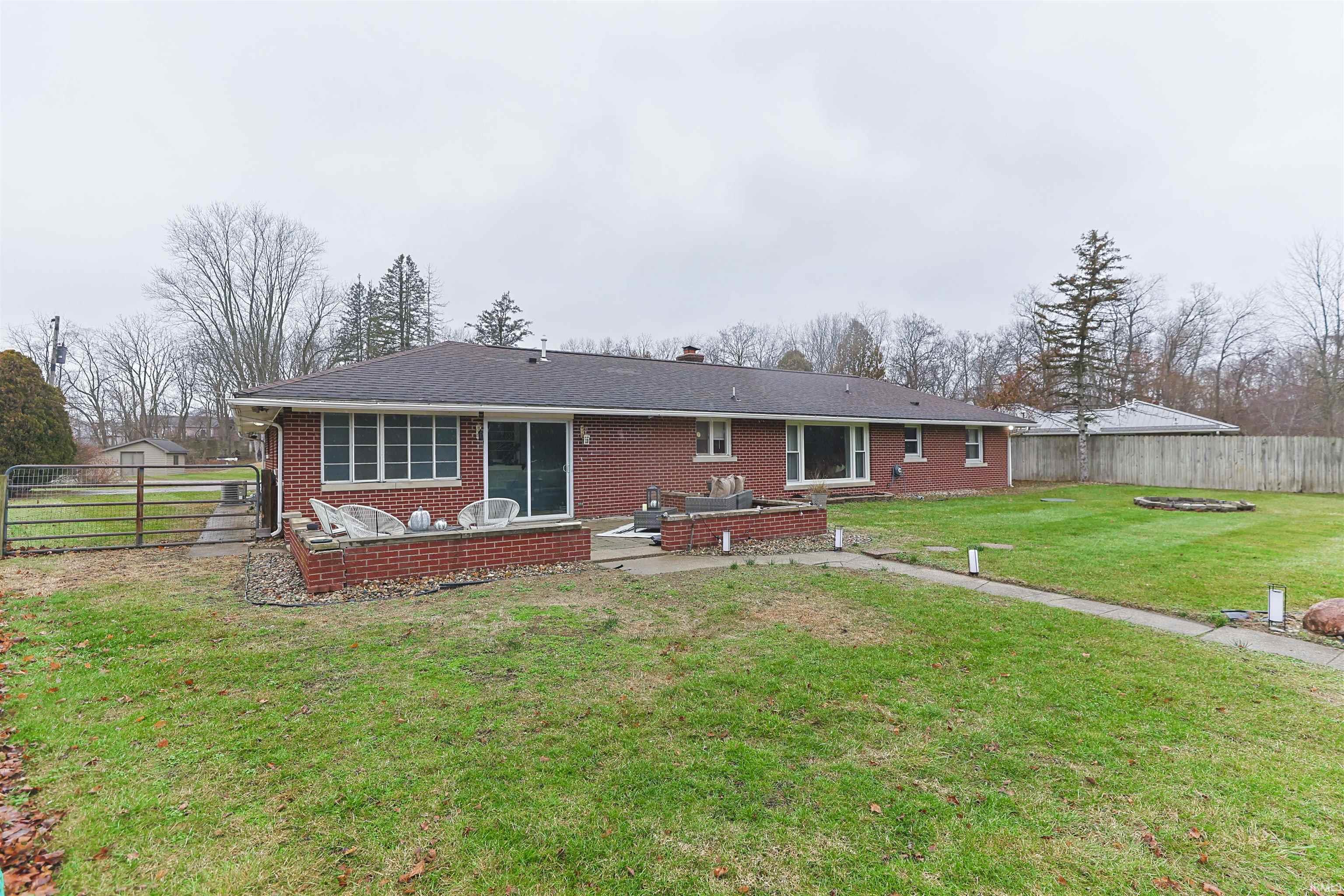 Back of property with a patio, a chimney, and brick siding