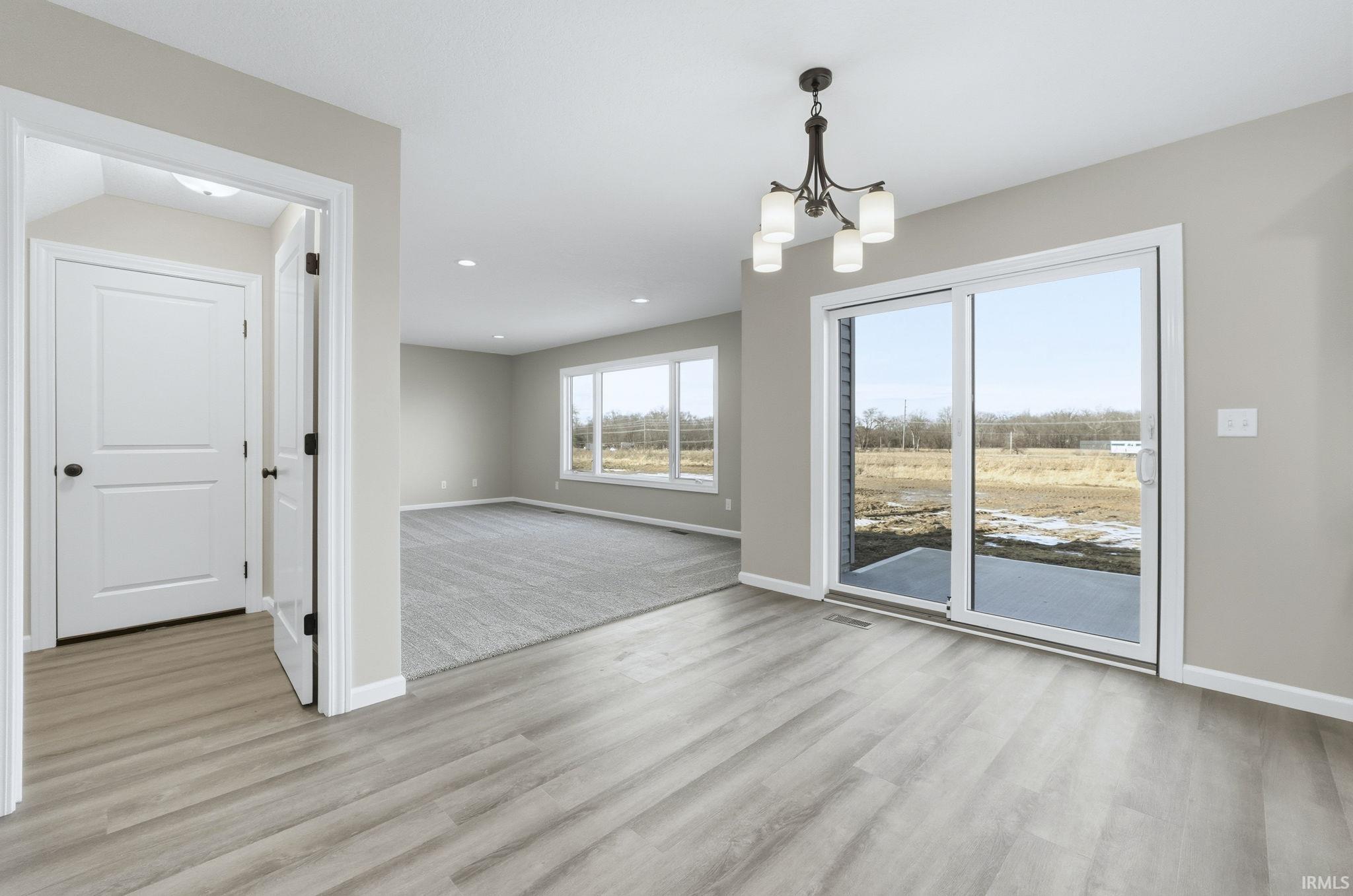 Unfurnished dining area with light wood finished floors, a chandelier, and recessed lighting