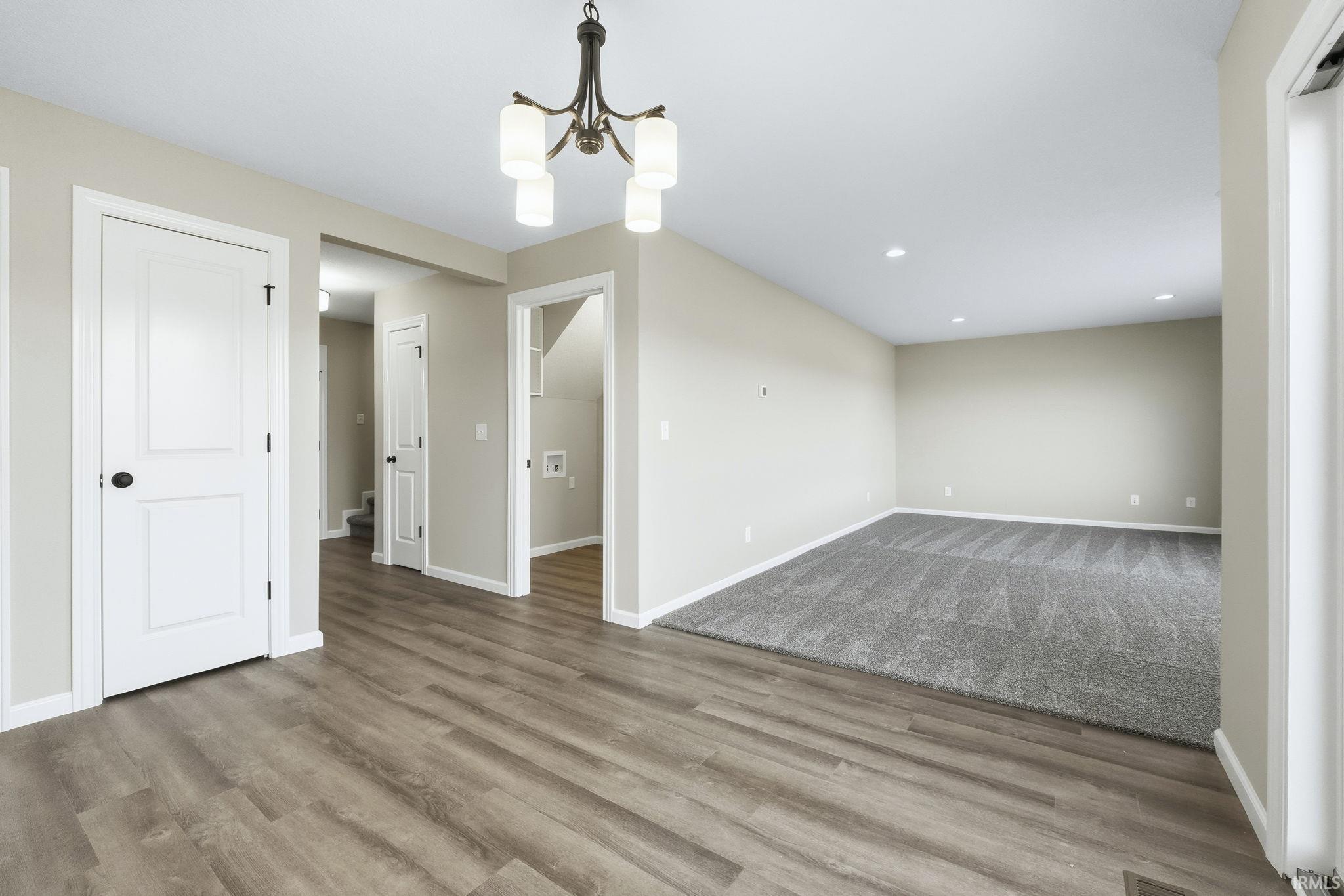 Empty room featuring a chandelier and light wood finished floors