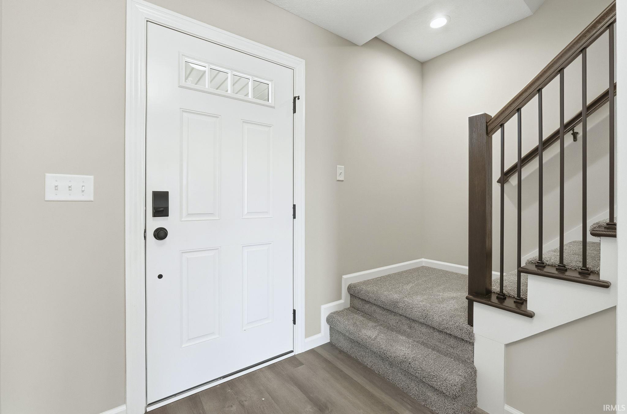 Entrance foyer with stairway and wood finished floors
