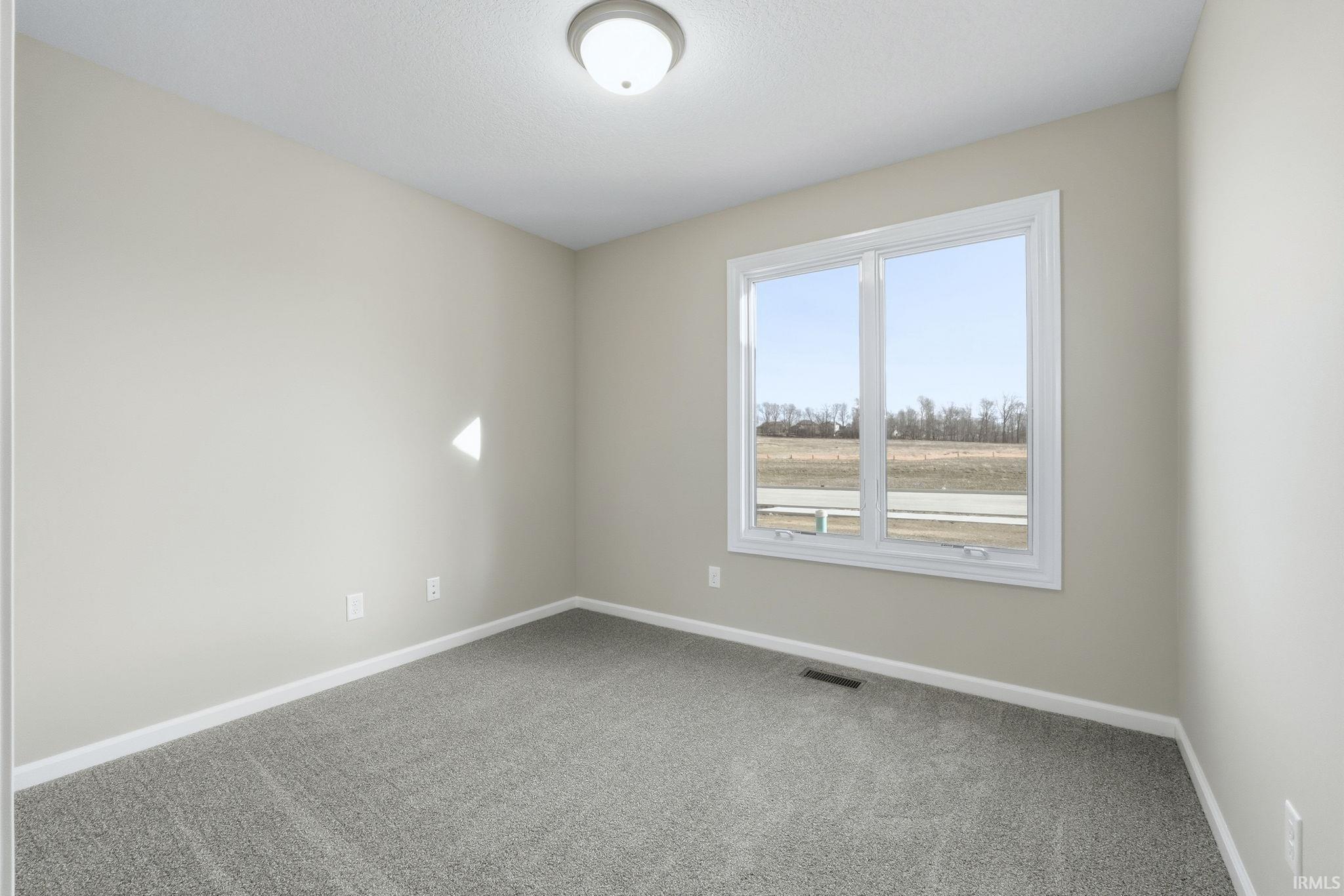 Carpeted empty room featuring baseboards