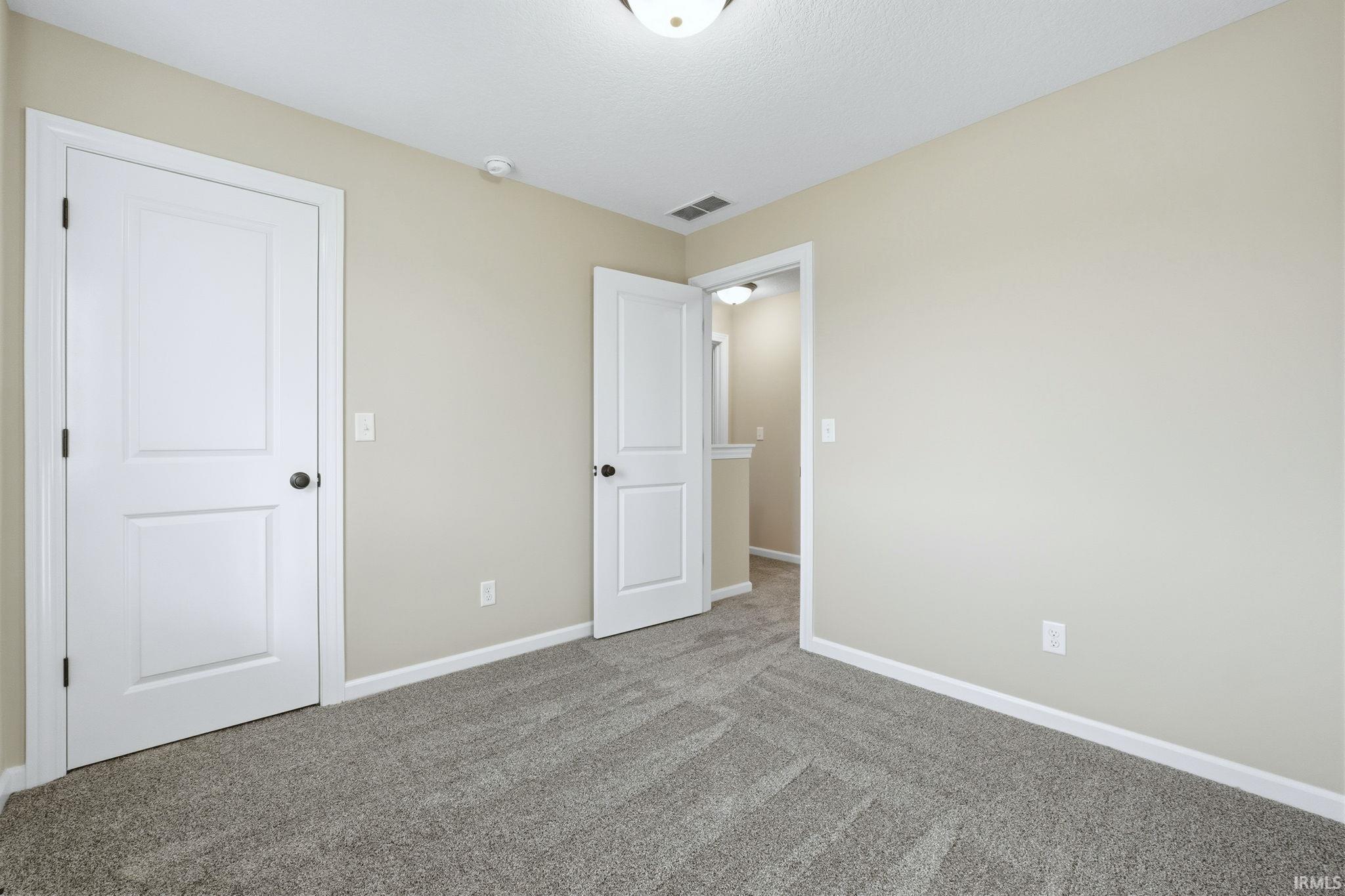 Unfurnished bedroom featuring baseboards and carpet