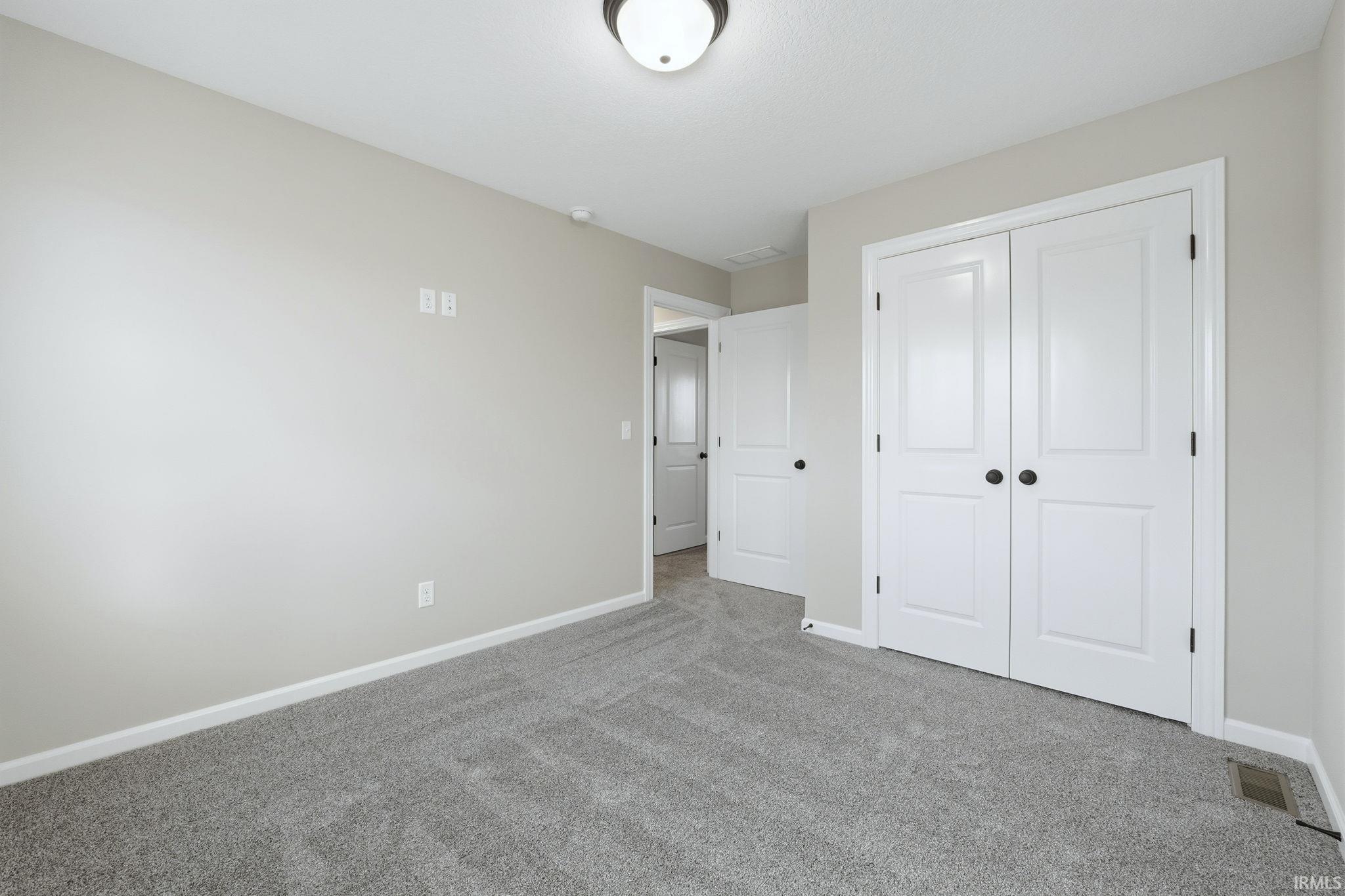 Unfurnished bedroom featuring carpet and a closet