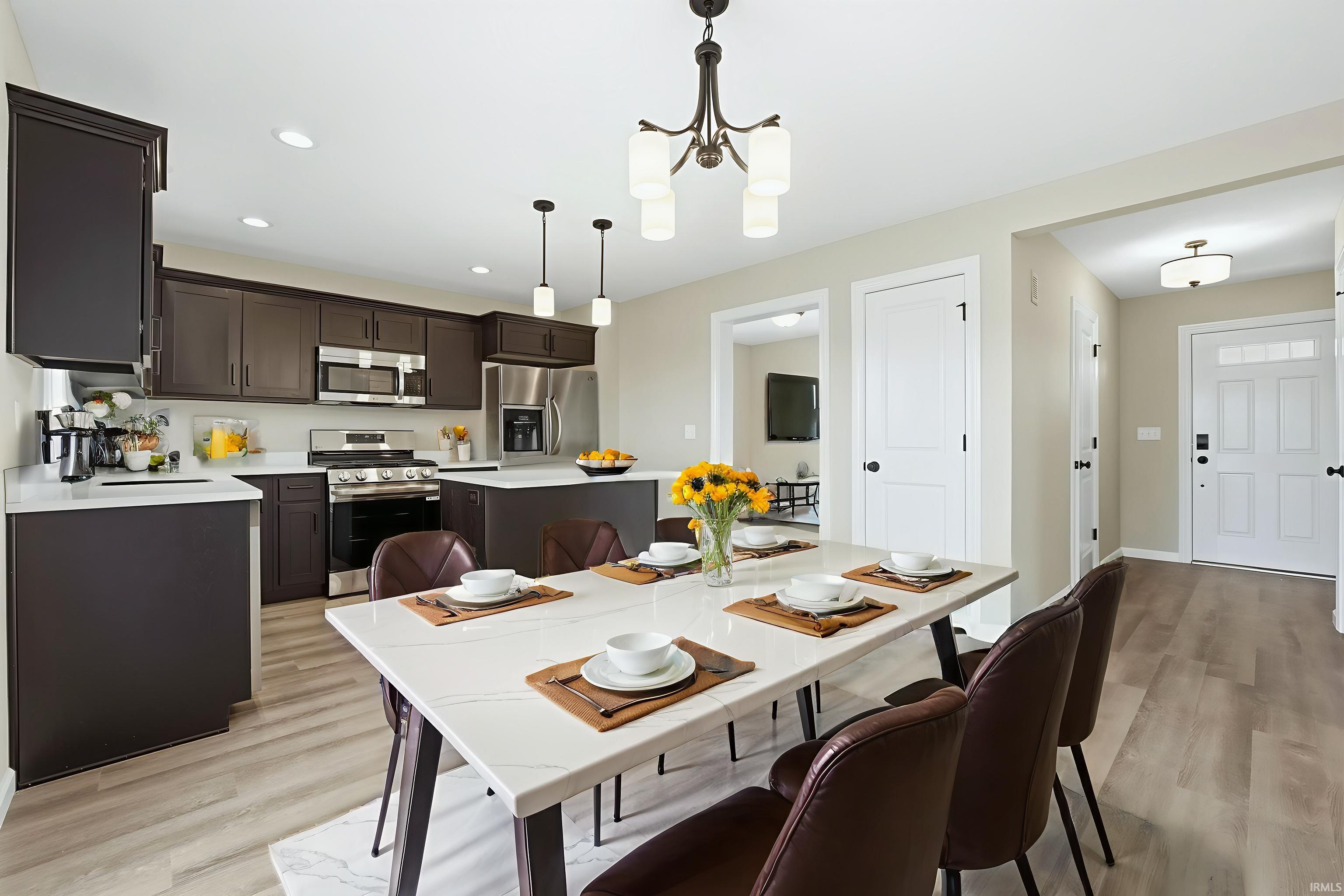 Dining room with light wood-type flooring, a chandelier, and recessed lighting